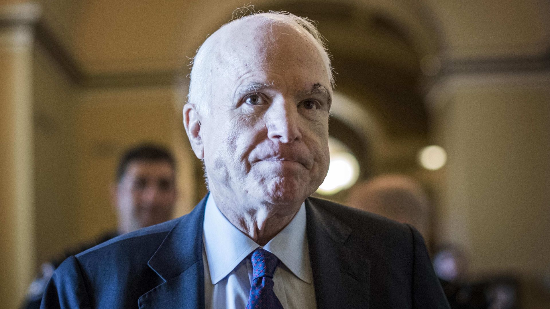 Sen John McCain walks down a hallway of the Capitol