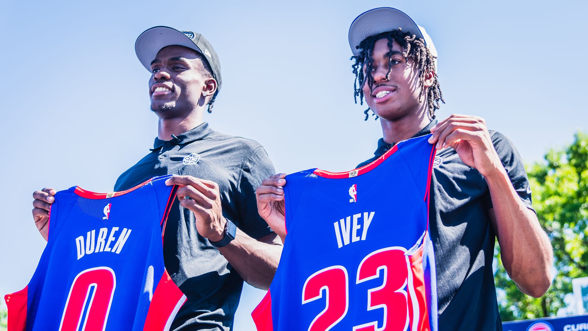 Jalen Duren and Jaden Ivey holding their new Pistons jerseys at a press conference in Detroit