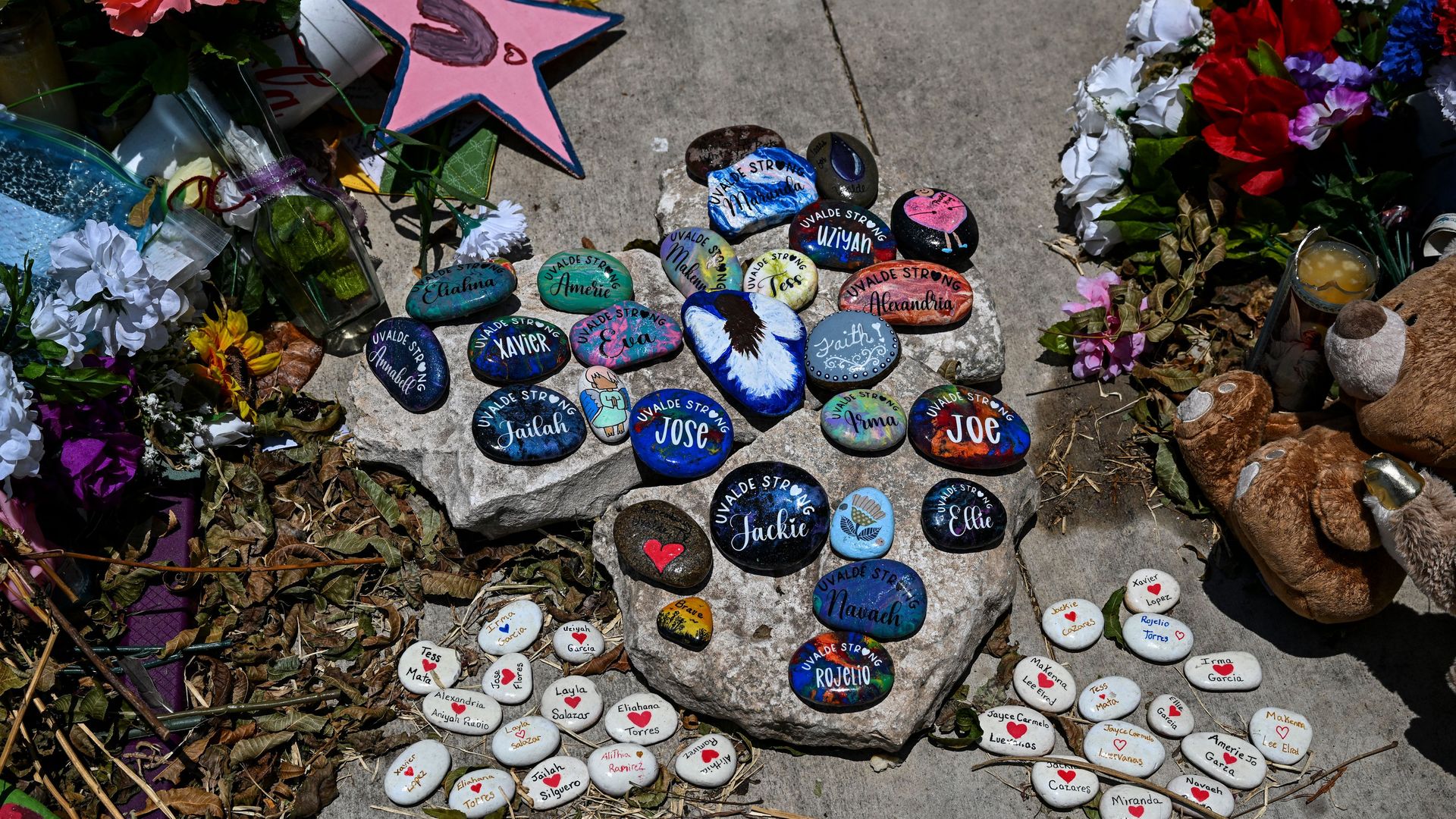 Small decorated rocks with the names of the victims of the elementary school shooting in Uvalde are stacked on the ground atop larger rocks