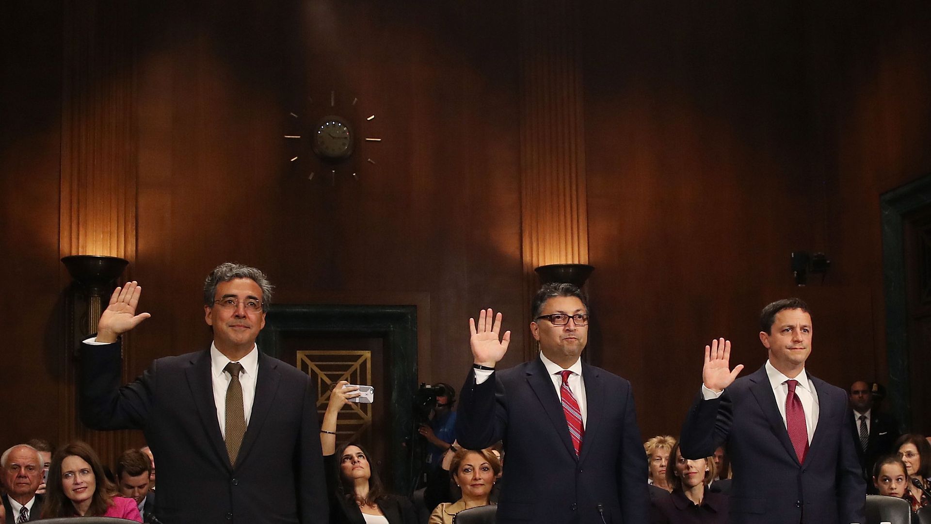 Three men, with Makan Delrahim at the center, raise their right hands before testifying in front of Congress