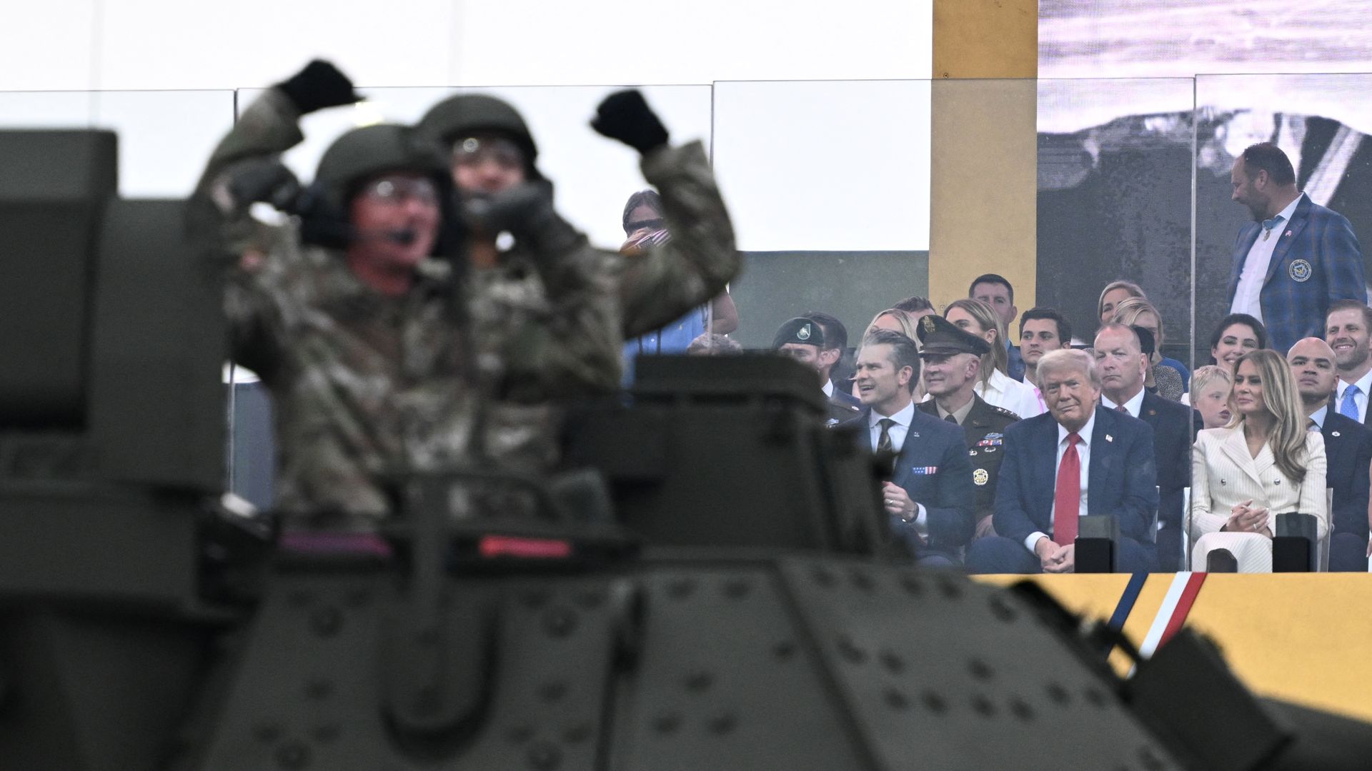 President Donald Trump (top, C), flanked by US First Lady Melania Trump and US Secretary of Defense Pete Hegseth, watches the Army 250th Anniversary Parade from the Ellipse in Washington, DC on June 14, 2025. 