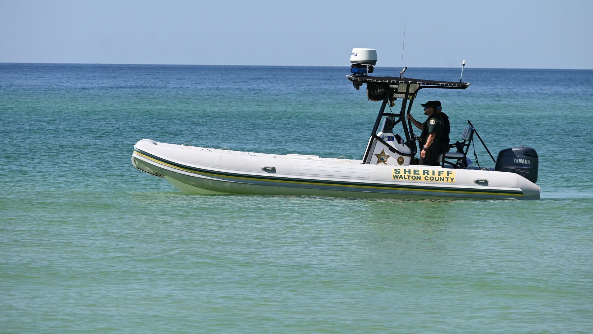 Photos shows a law enforcement boat patrolling the water at the beach in Florida.