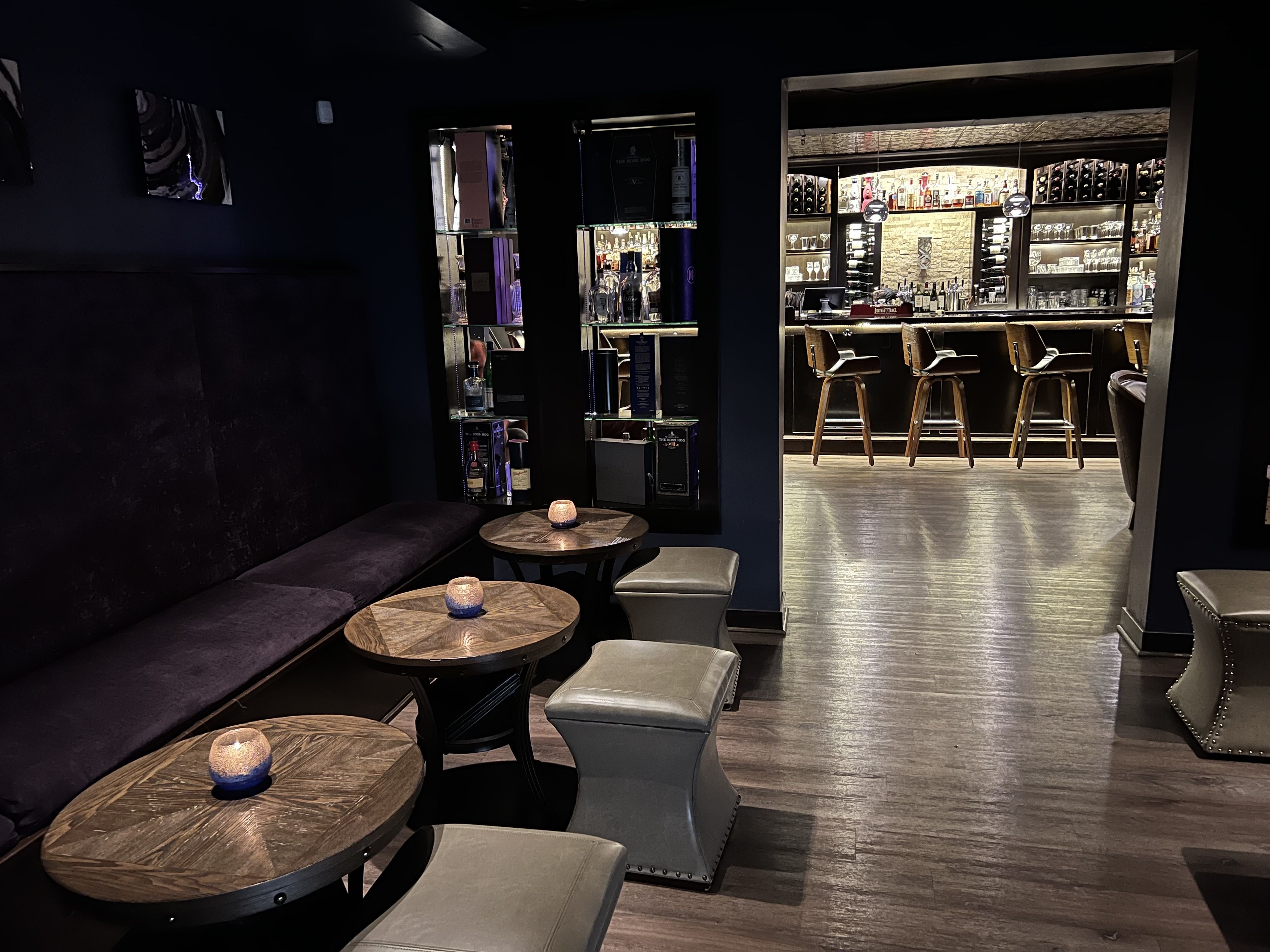 A dark bar with candles on the tables