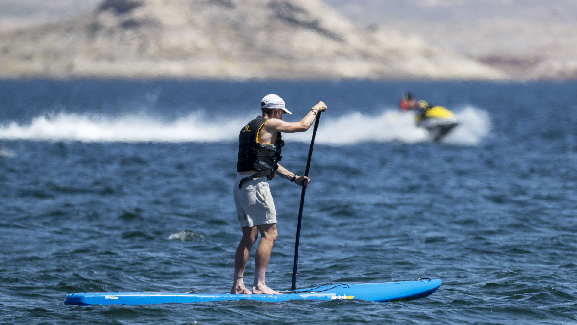 A man paddle boarding on a lake. 