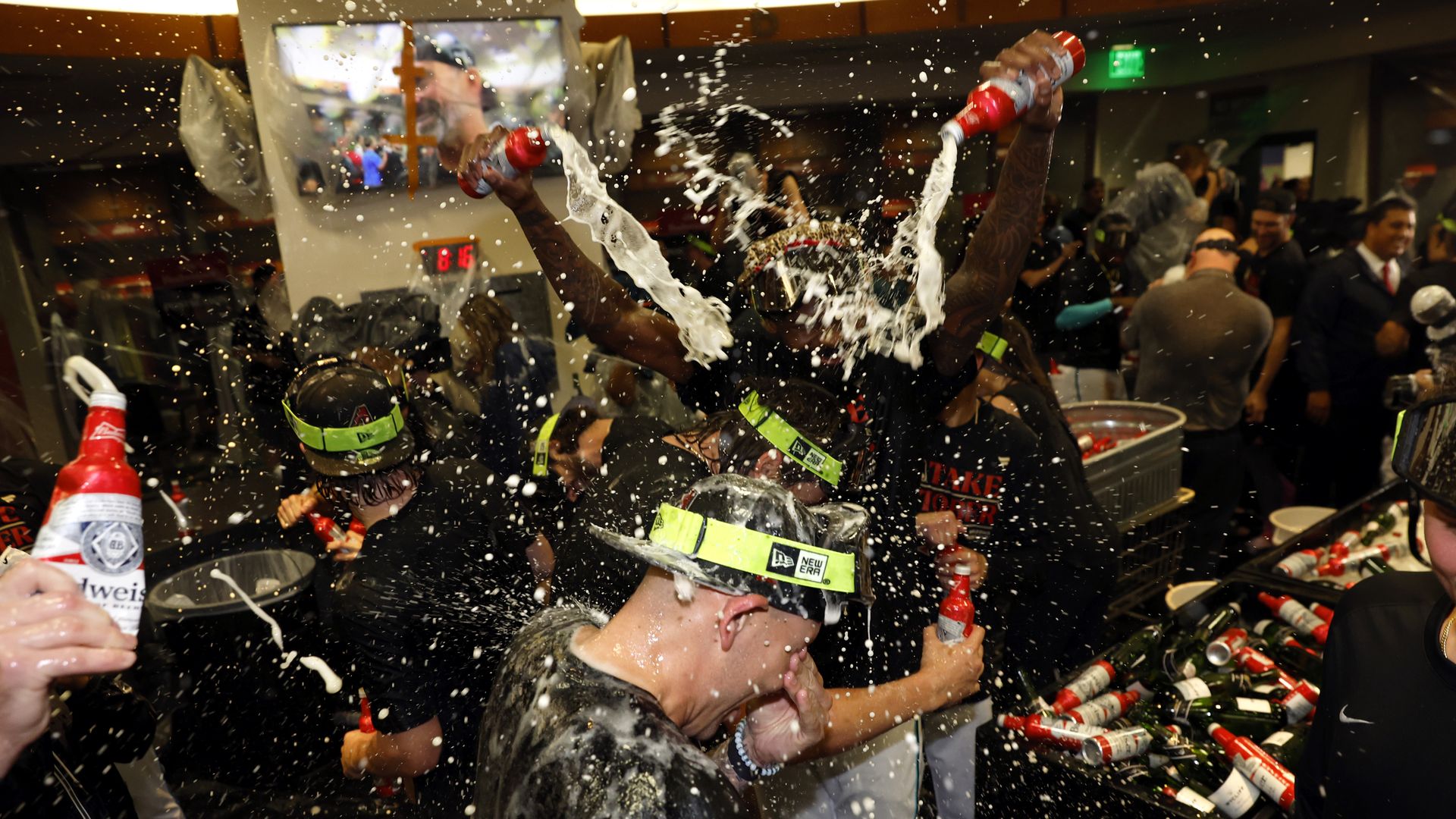 A group of celebrating people  pour beer over each other.