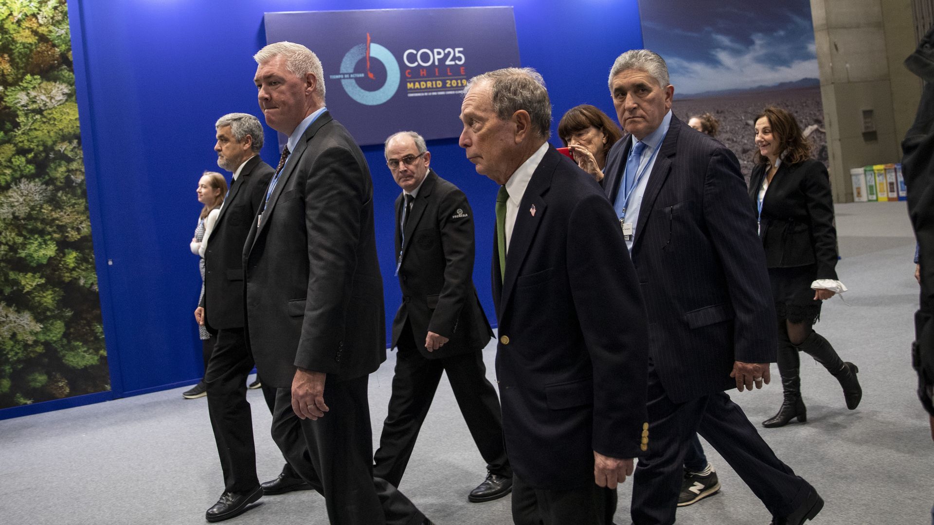 Michael Bloomberg walks with his entourage at a climate summit.