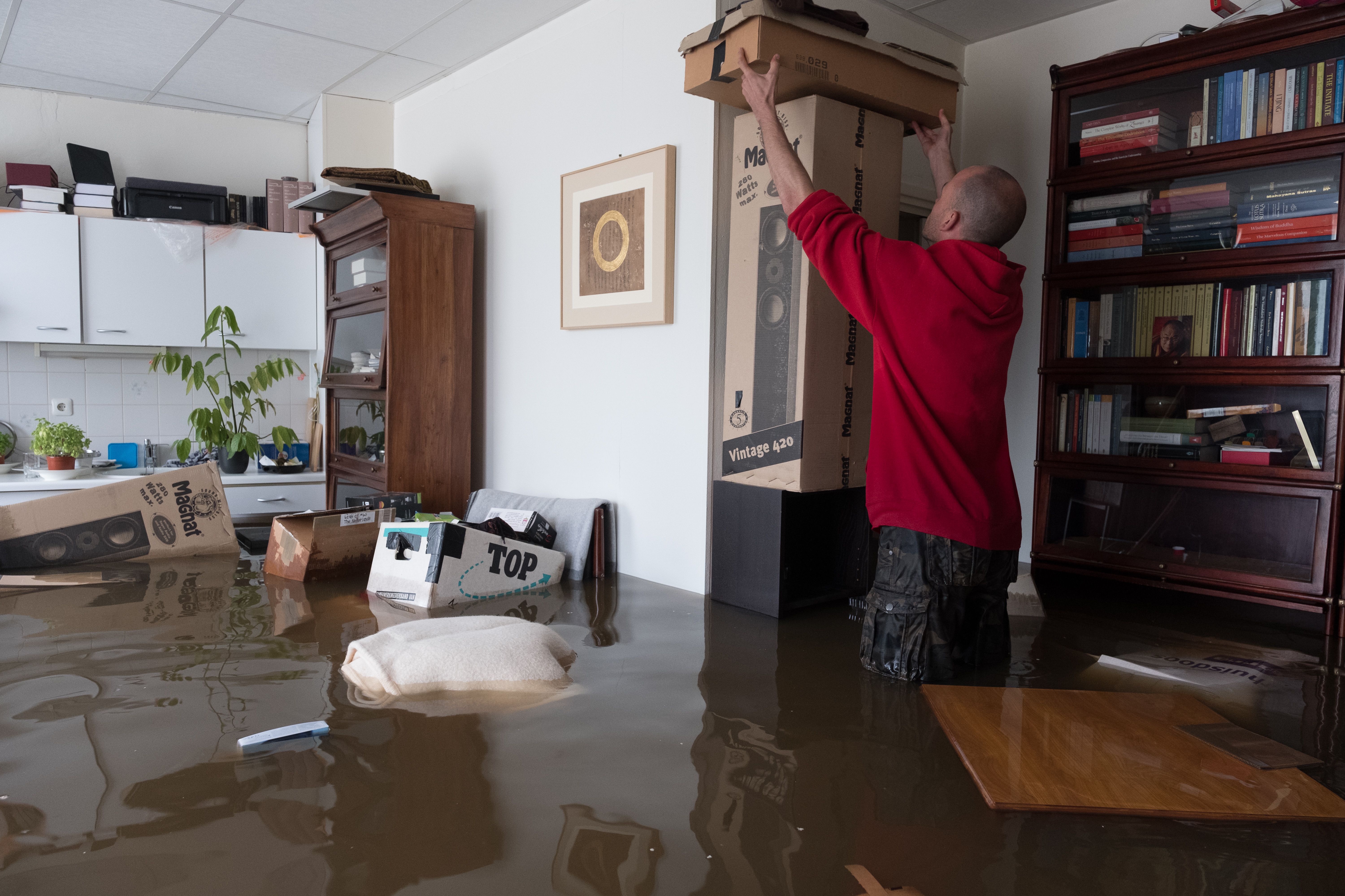 A man moves possesions inside a flooded house on July 16, 2021 in Geulle, Netherlands.