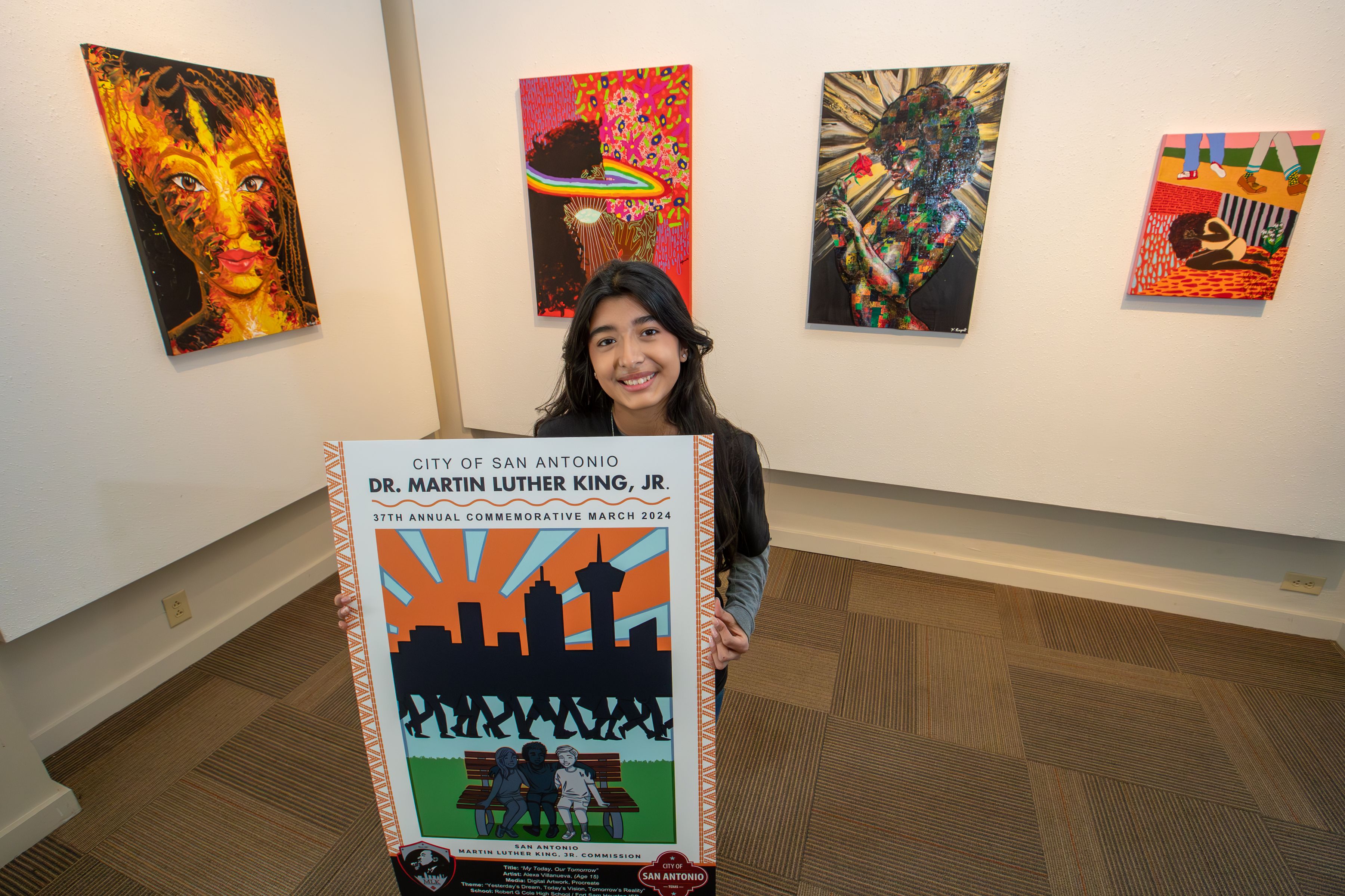A young teen holds a poster depicting the skyline of San Antonio. 
