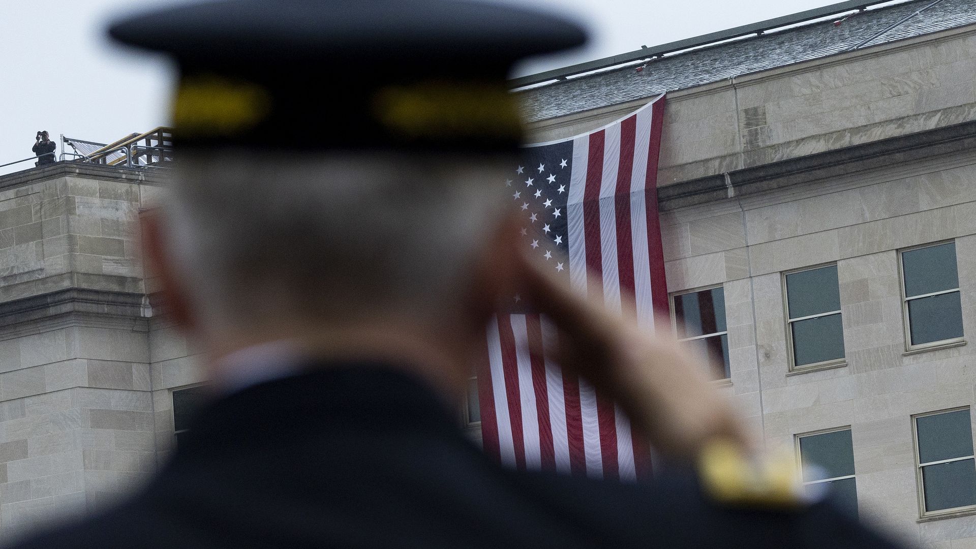 A service member salutes the U.S. flag at the Pentagon