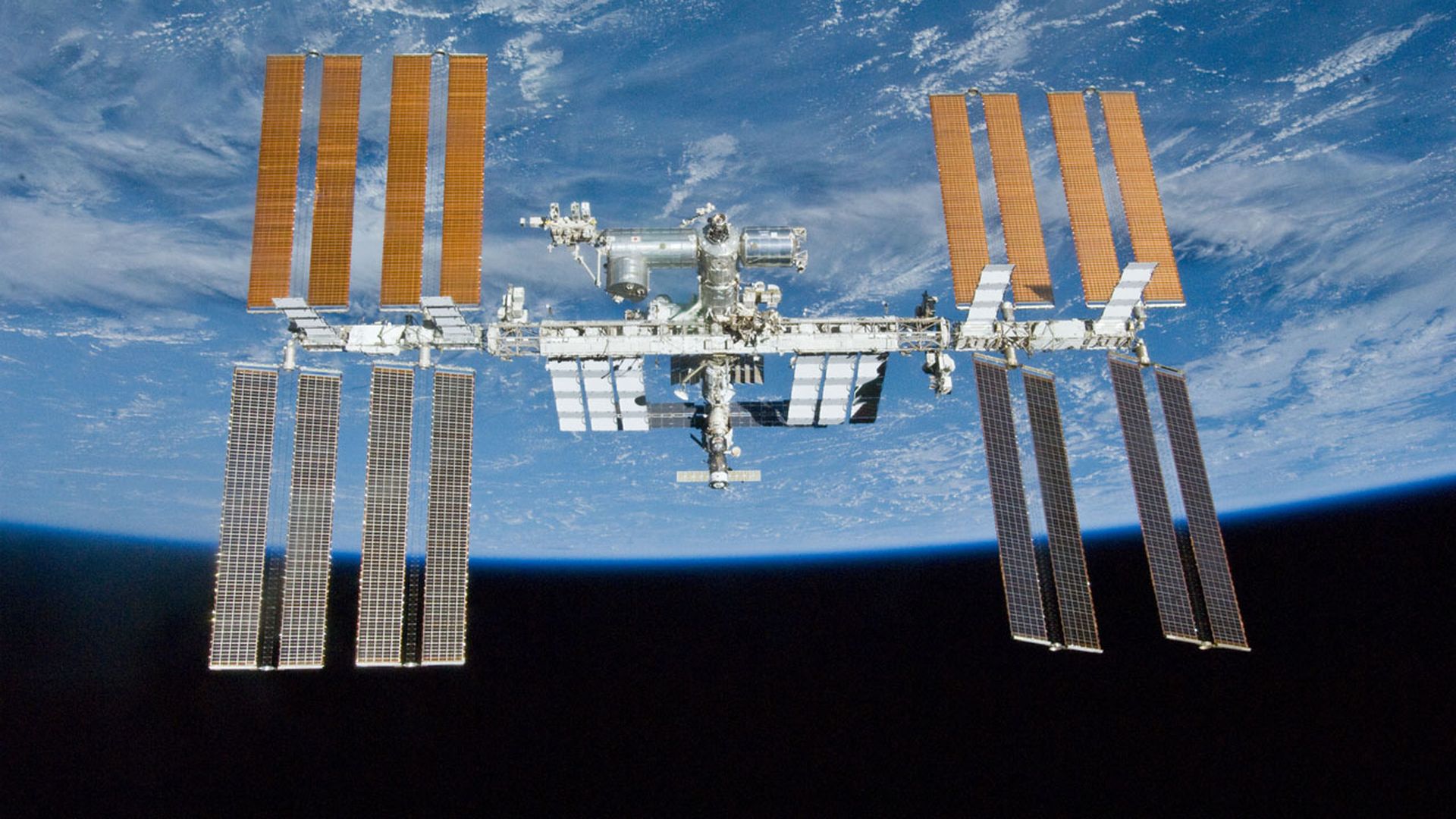 The International Space Station seen from a distance with the Earth behind it