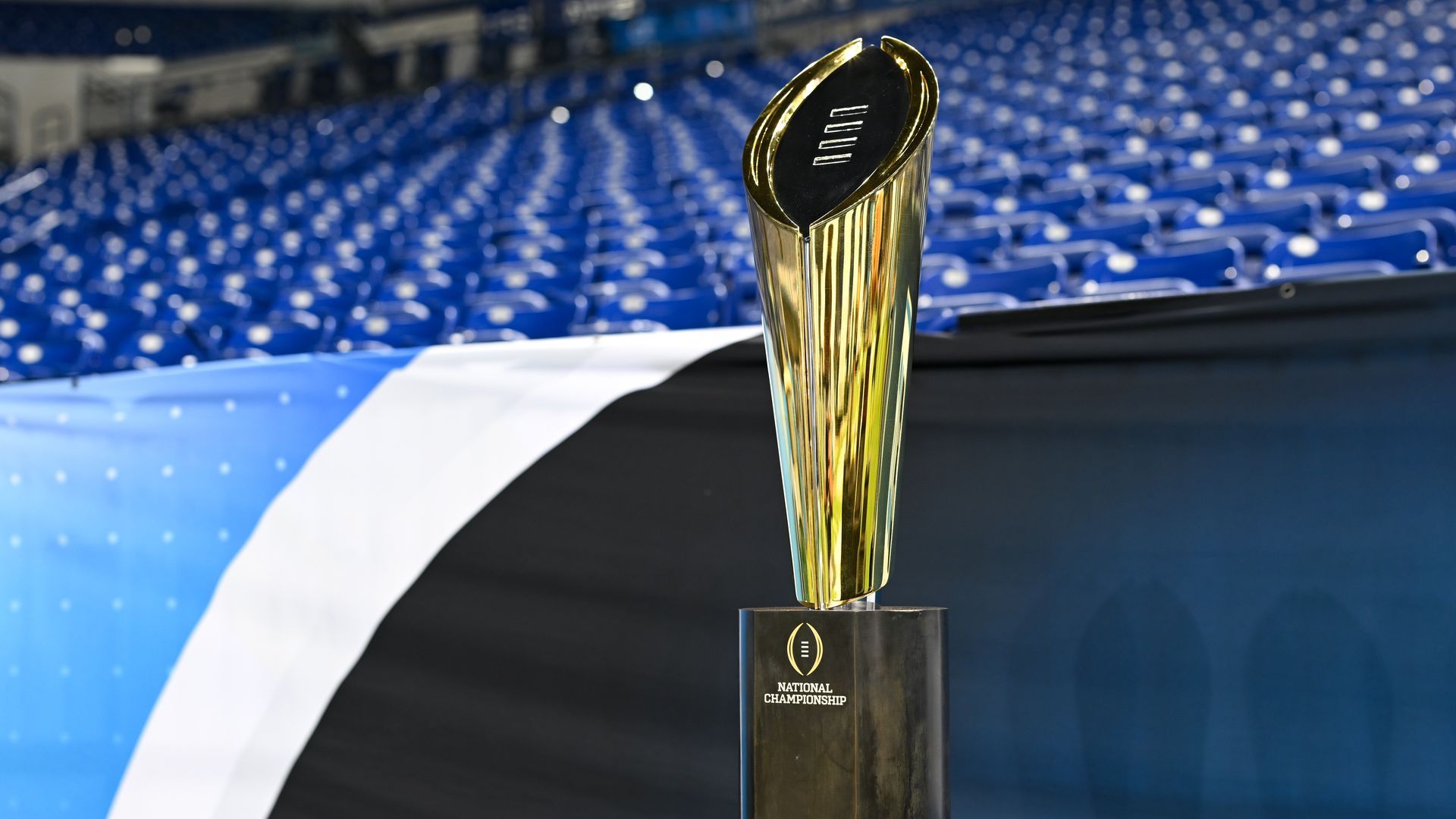 The College Football Playoff trophy sits in an empty stadium. 