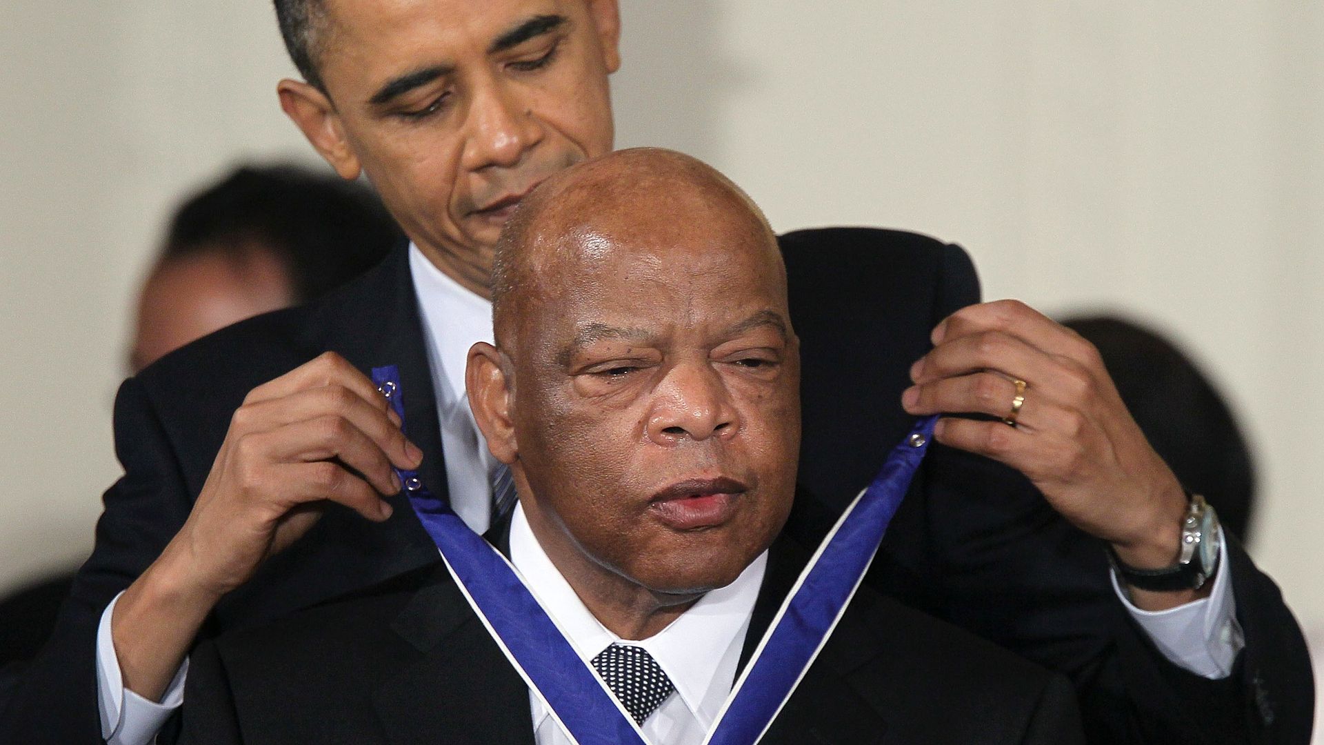 President Obama puts the Medal of Freedom around John Lewis's neck