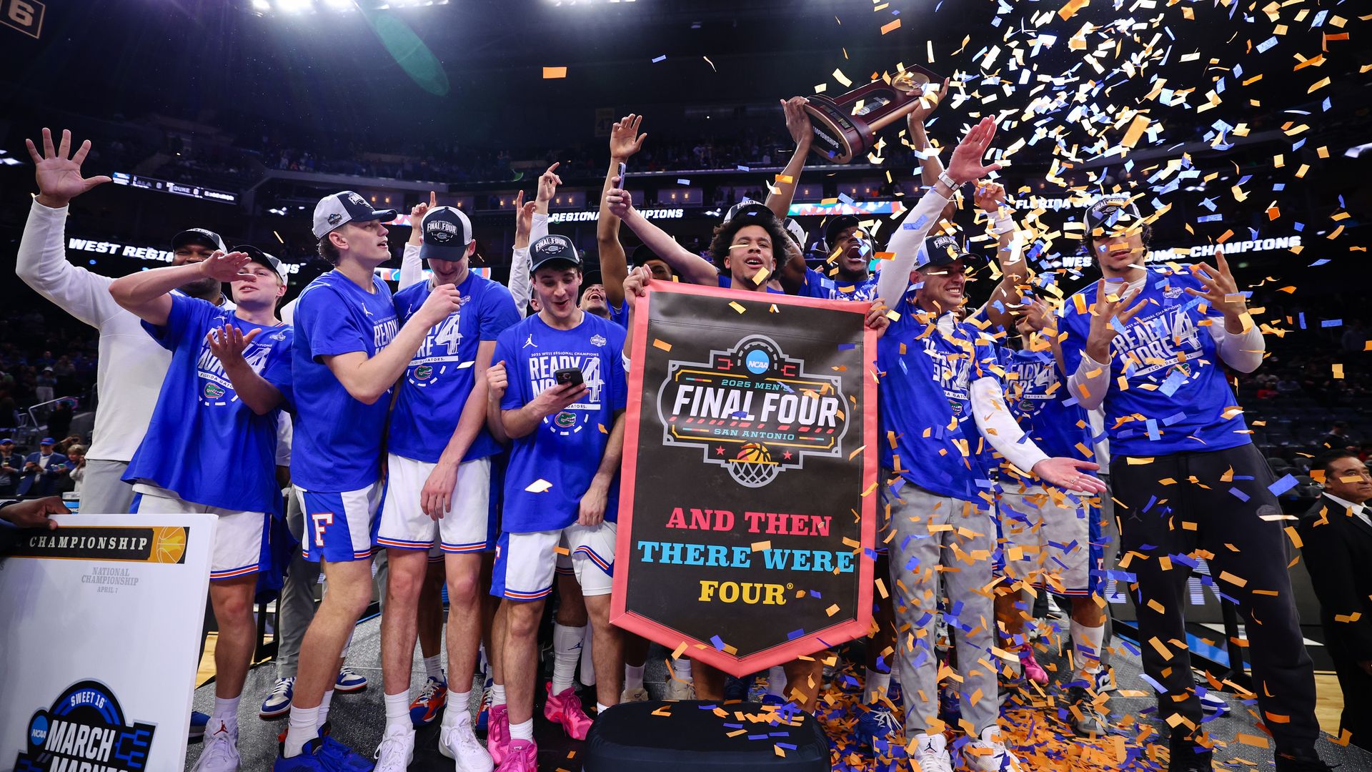A group of men celebrate under a plume of confetti. 