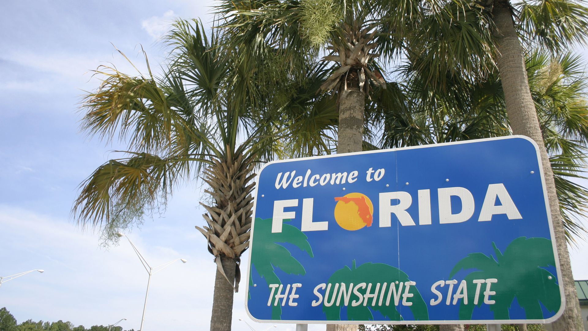 Welcome to Florida sign in front of palm trees