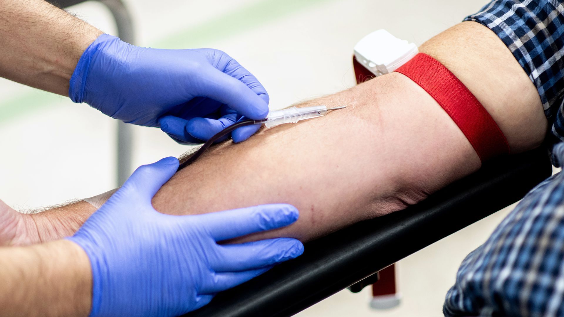 Someone inserts a needle into another person's arm