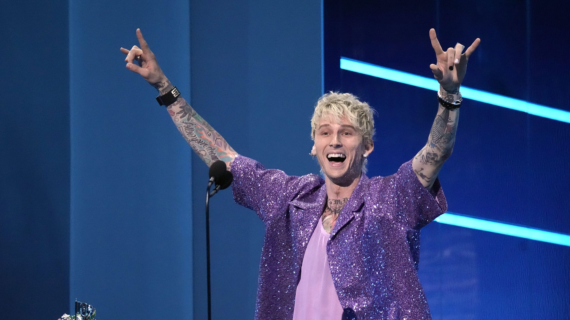 Machine Gun Kelly holds up hand-shaped devil horns to celebrate winning and MTV Video Music Award.