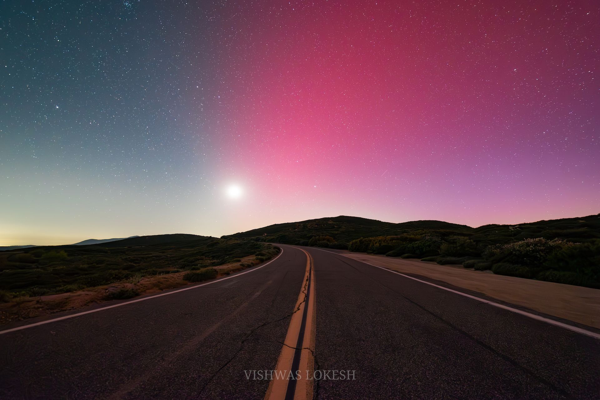A view of a road and The Northern Lights.