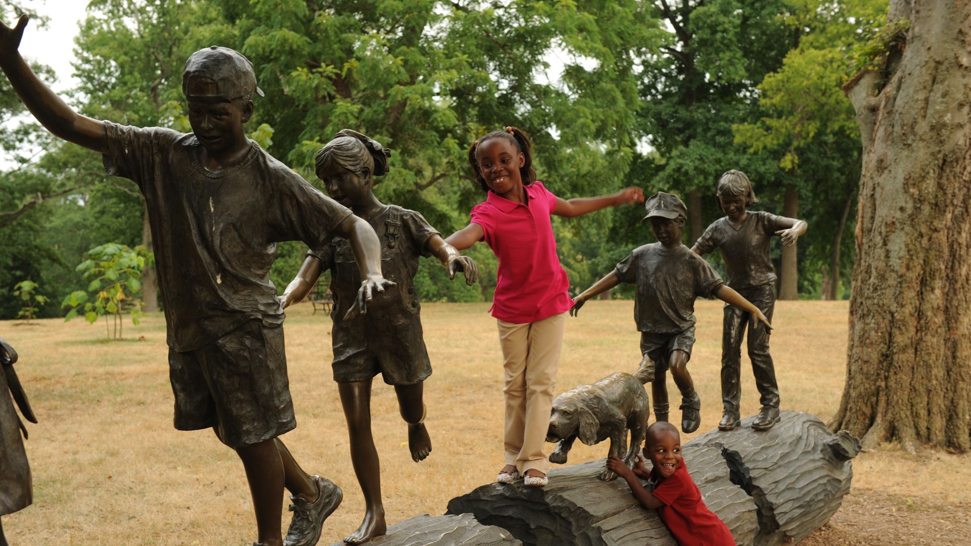 Children playing on a log at Maymont 