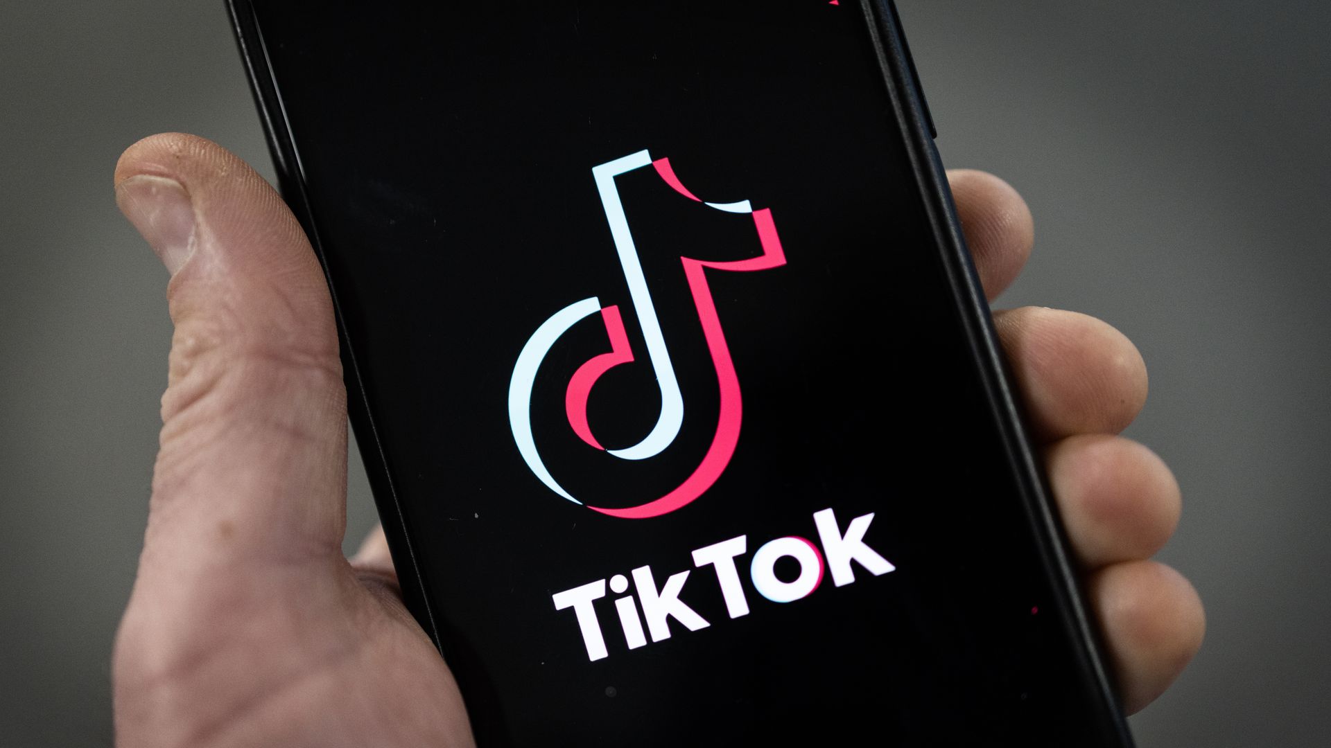 a TikTok logo is displayed on an iPhone