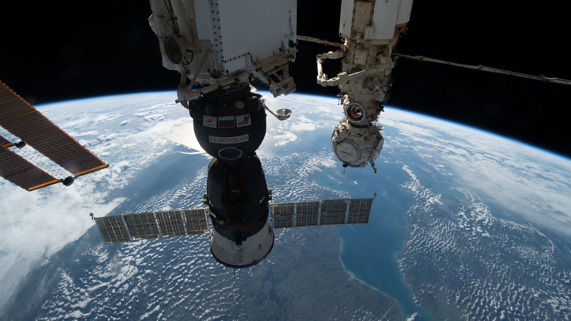 A Soyuz spacecraft attached to the International Space Station above the Earth