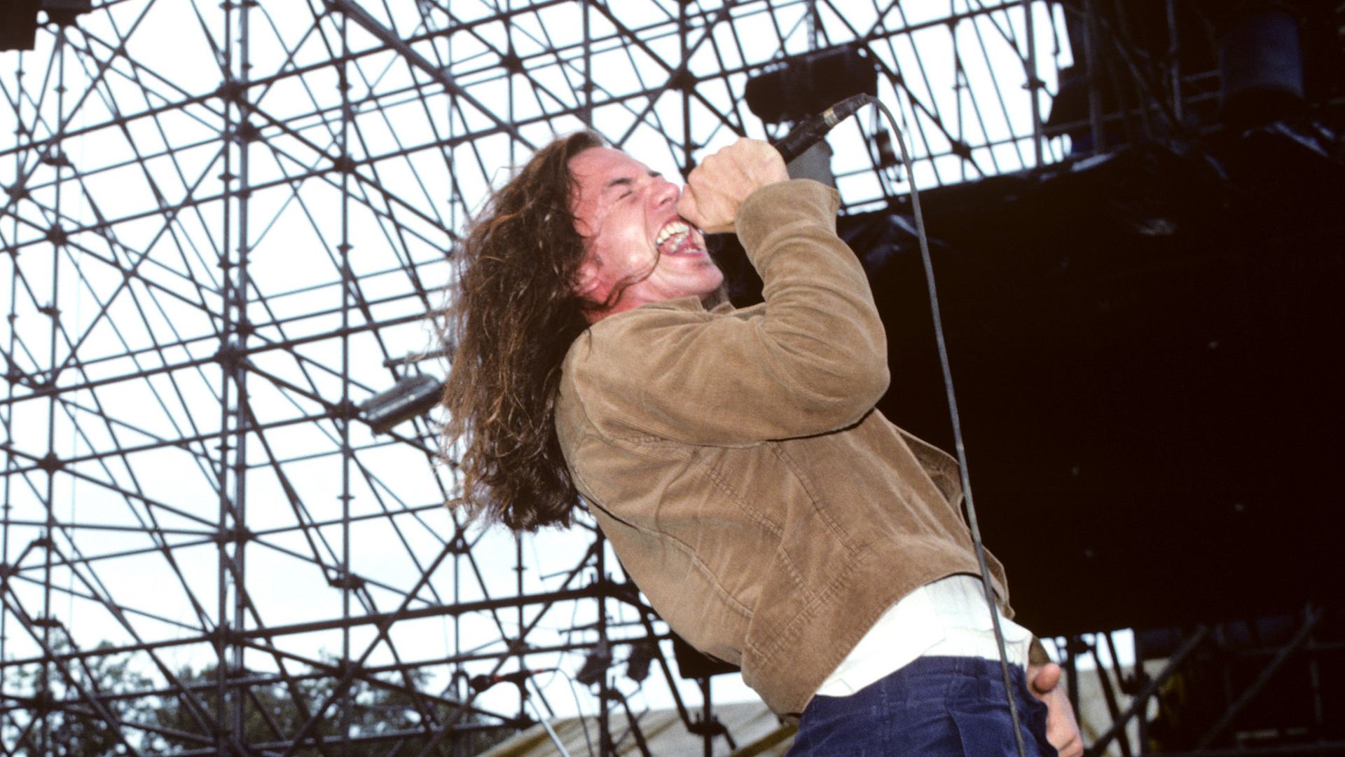 Eddie Vedder of Pearl Jam performs on an outdoor stage. 