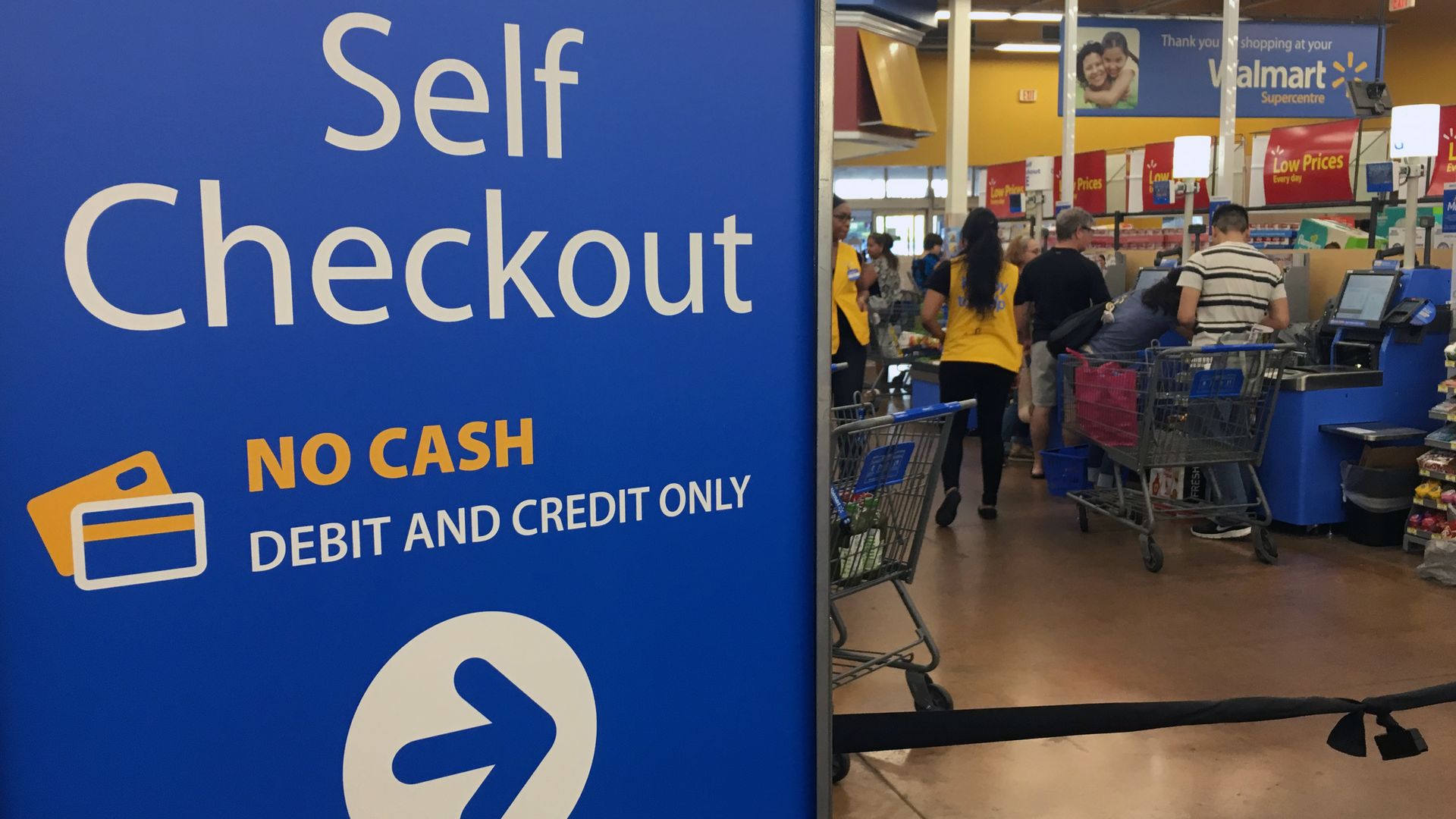 A Walmart sign pointing toward self checkout