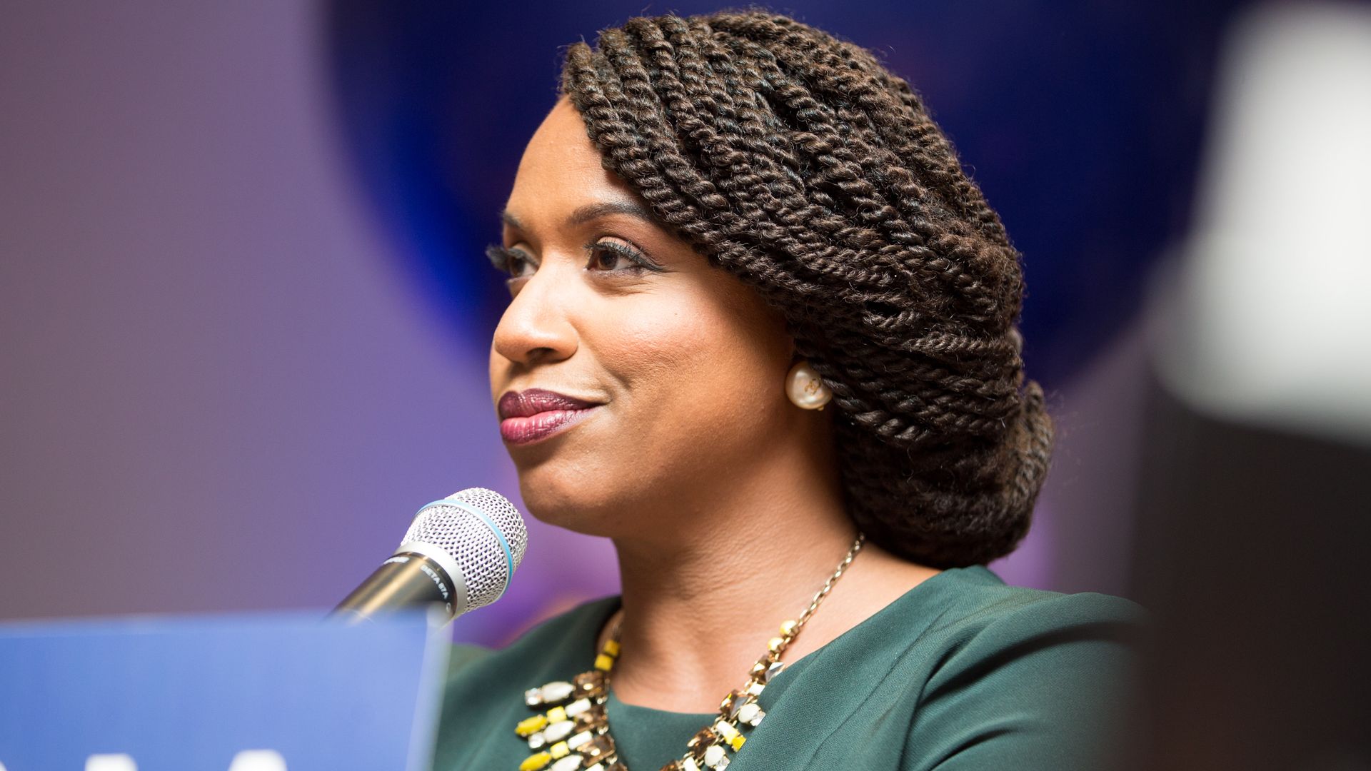Ayanna Pressley smiling at a podium.