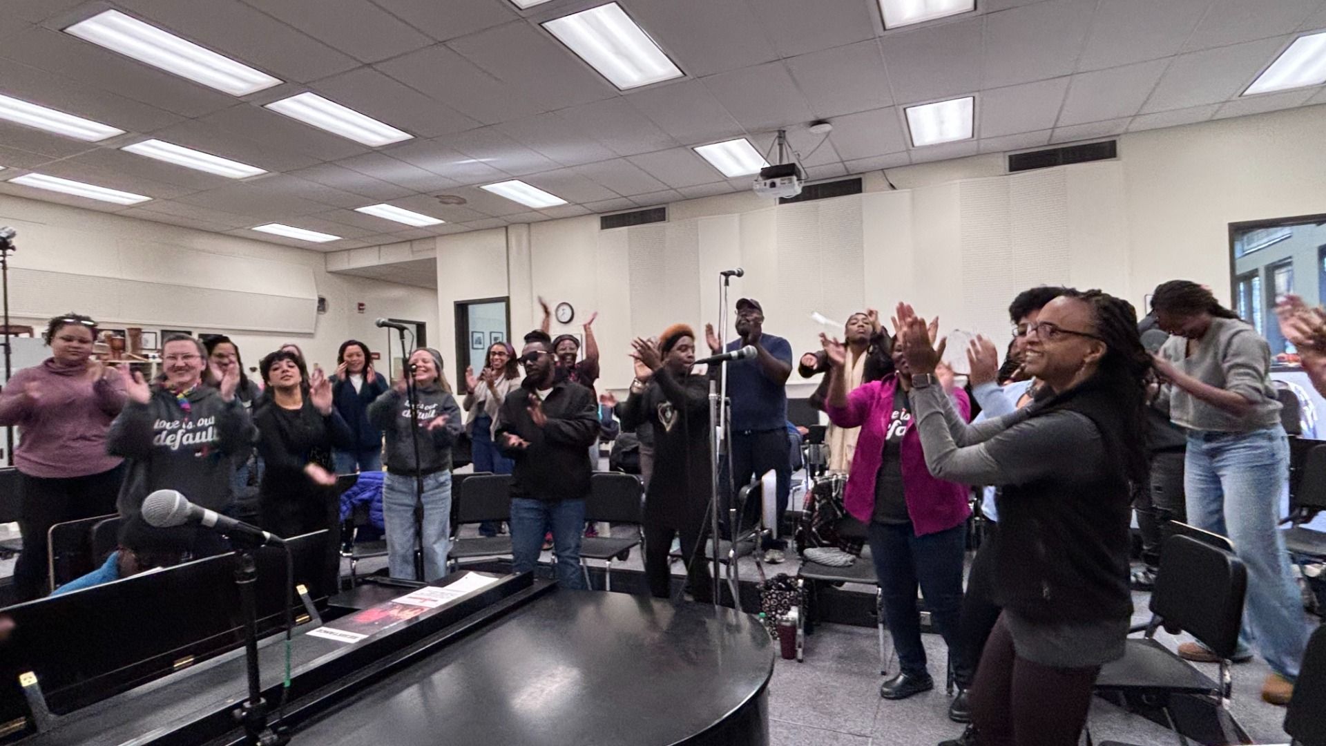 Members of Resounding Love clap and sing together during a joyful gospel rehearsal.