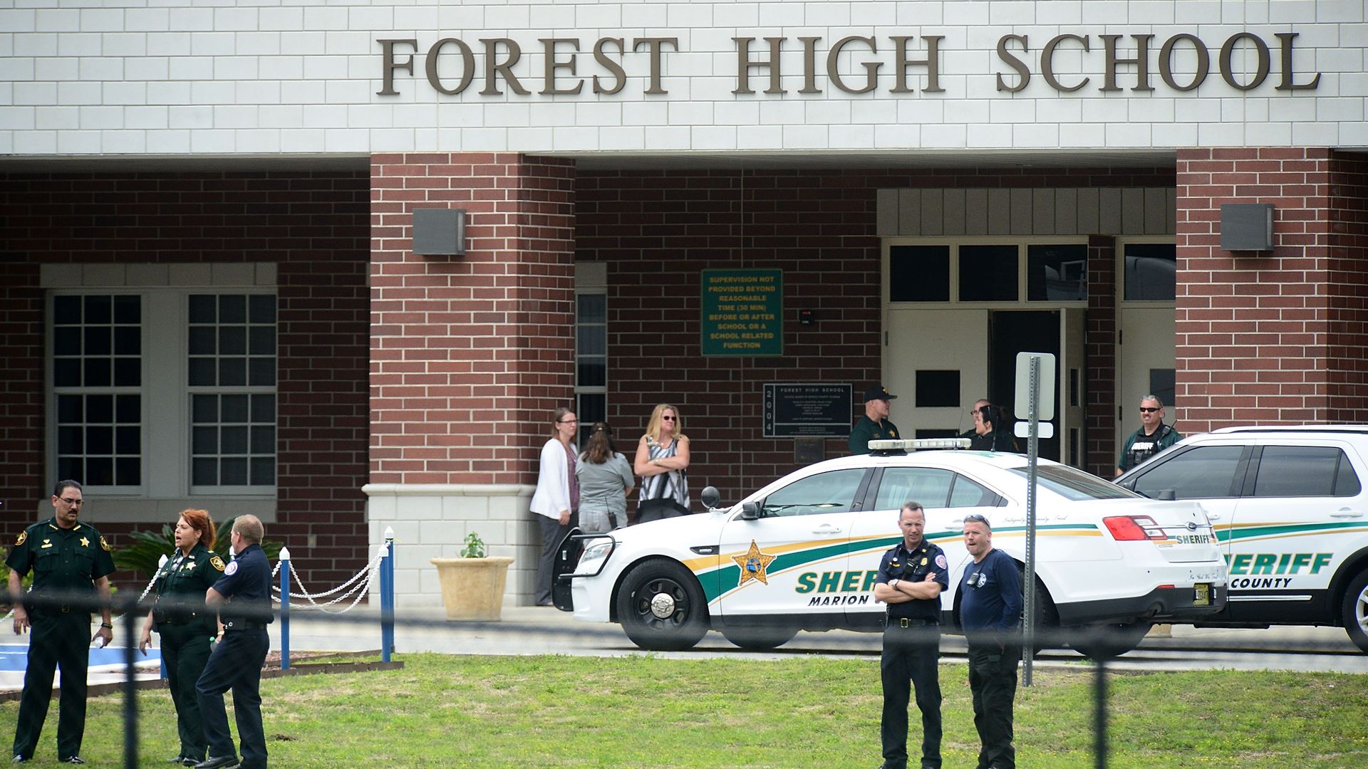 Marion County Police officers stand in front of Forest High School 