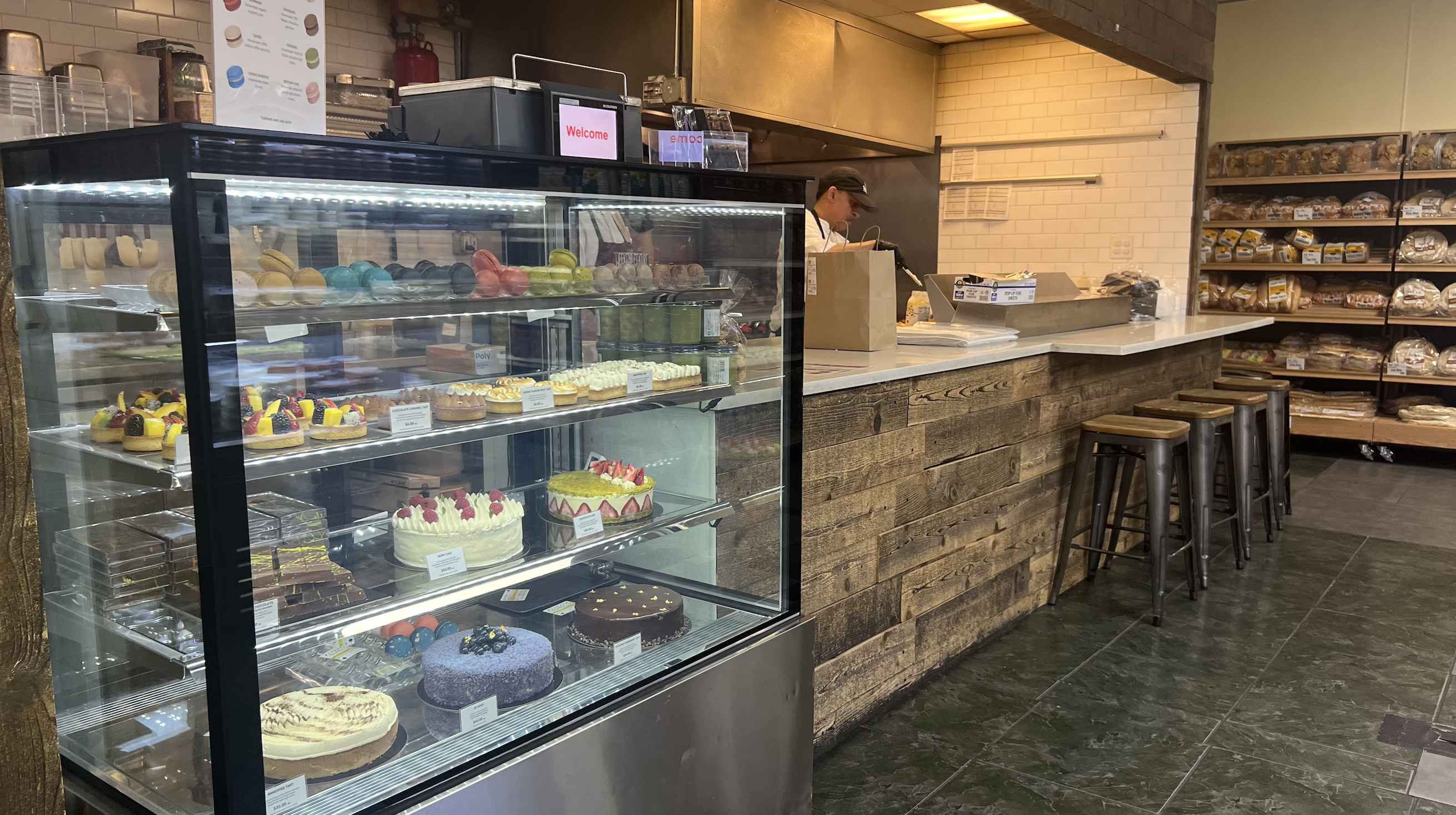A bakery counter with a man standing behind it