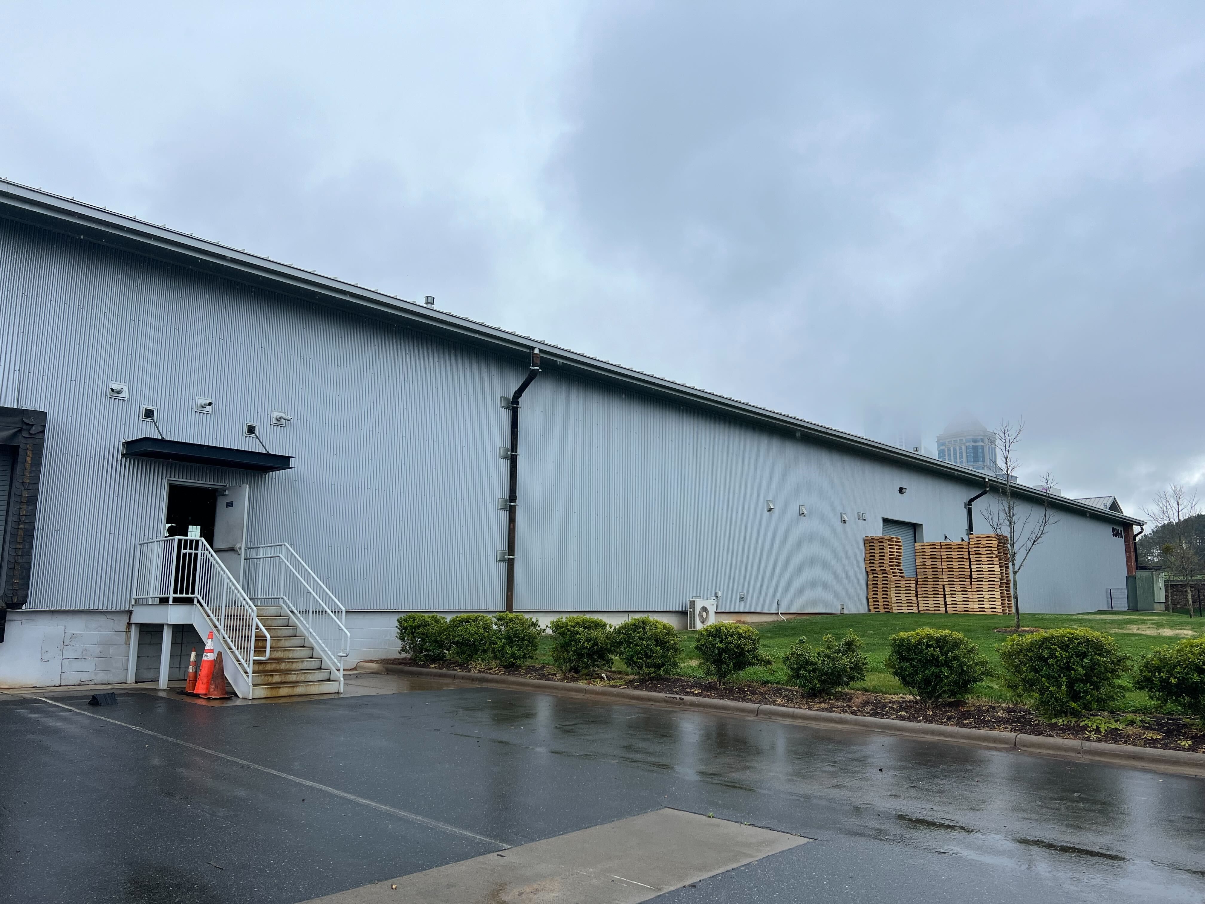 exterior of an industrial warehouse with a foggy sky behind it