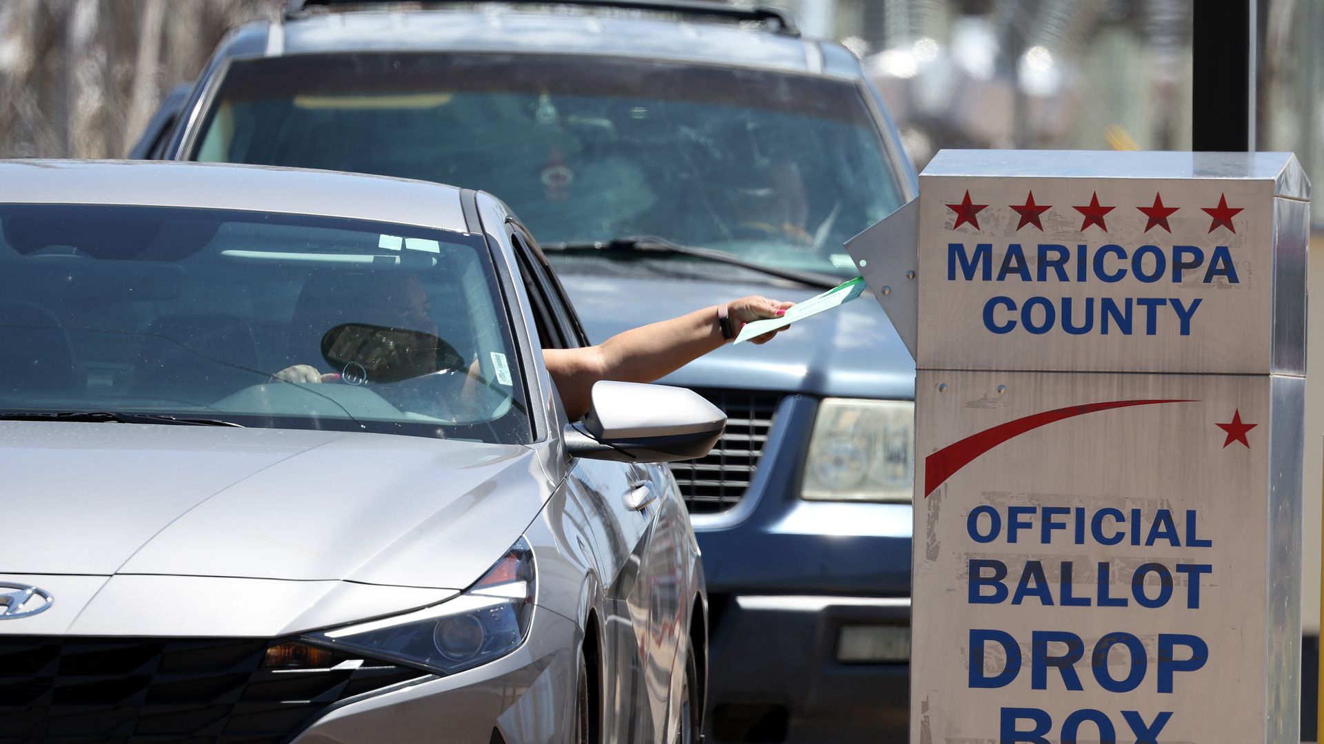 A person dropping a ballot into a drop box outside of the Maricopa County Elections Department in Phoenix in August 2022.