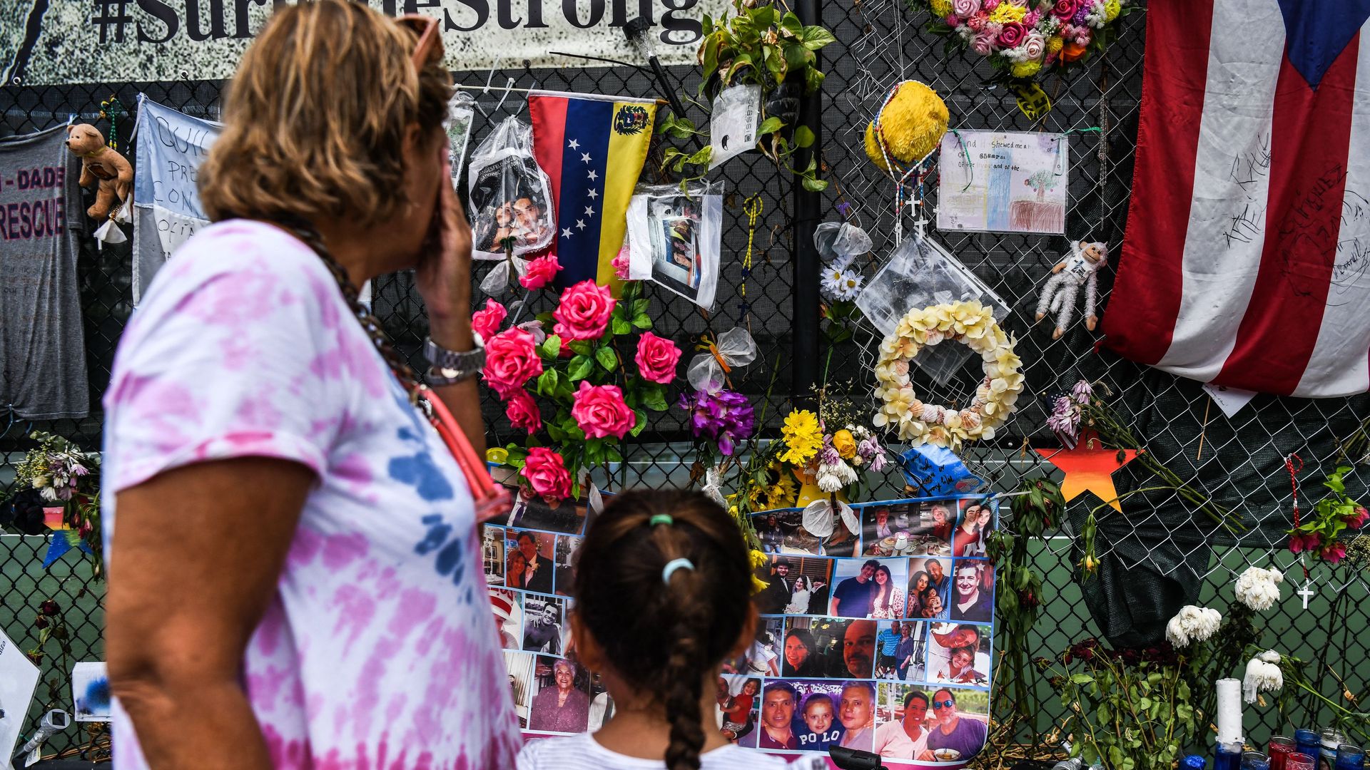 A woman cries as she visits a makeshift memorial where the partially collapsed Champlain Towers South building stood in Surfside, Florida on July 24, 2021