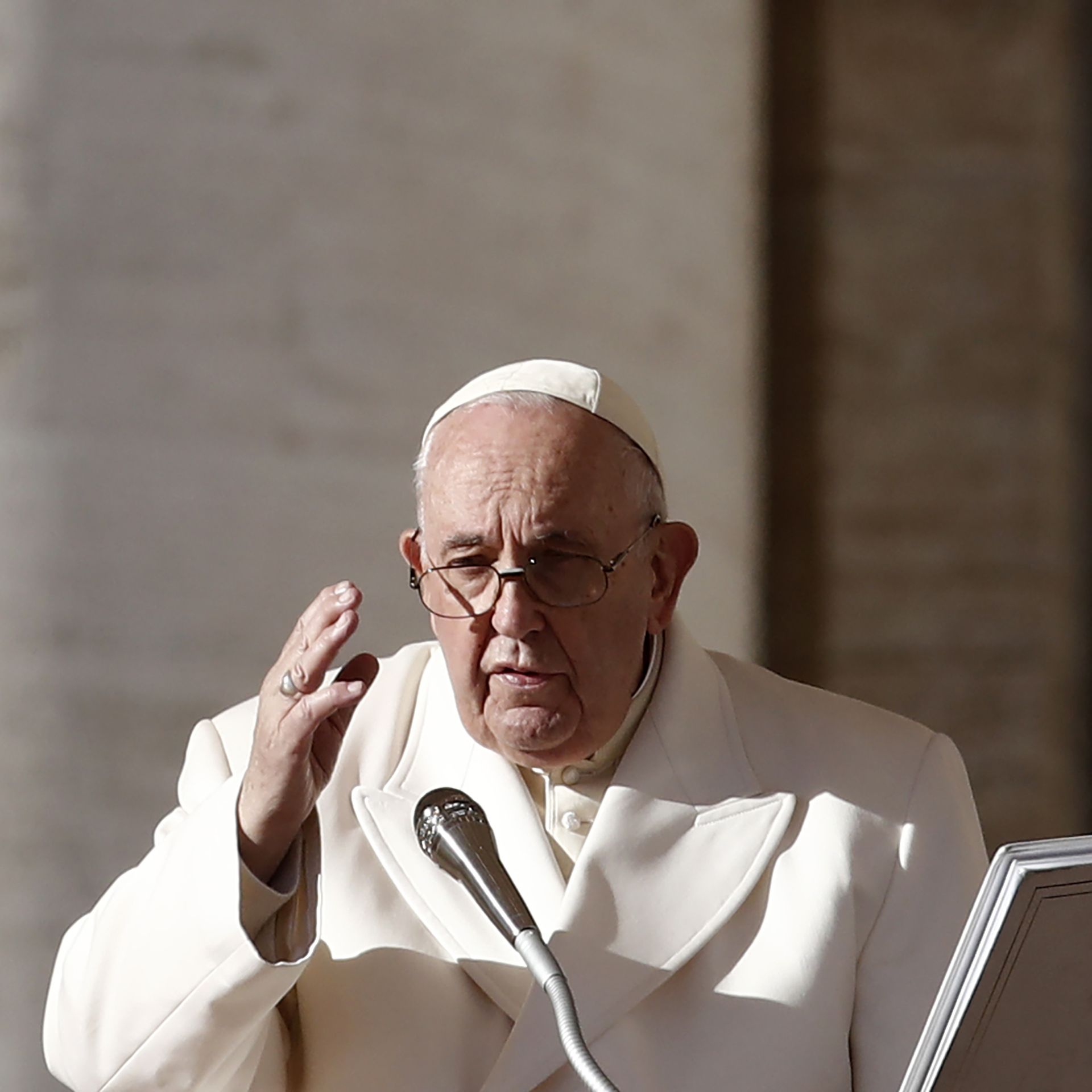 Photo of Pope Francis speaking into a mic