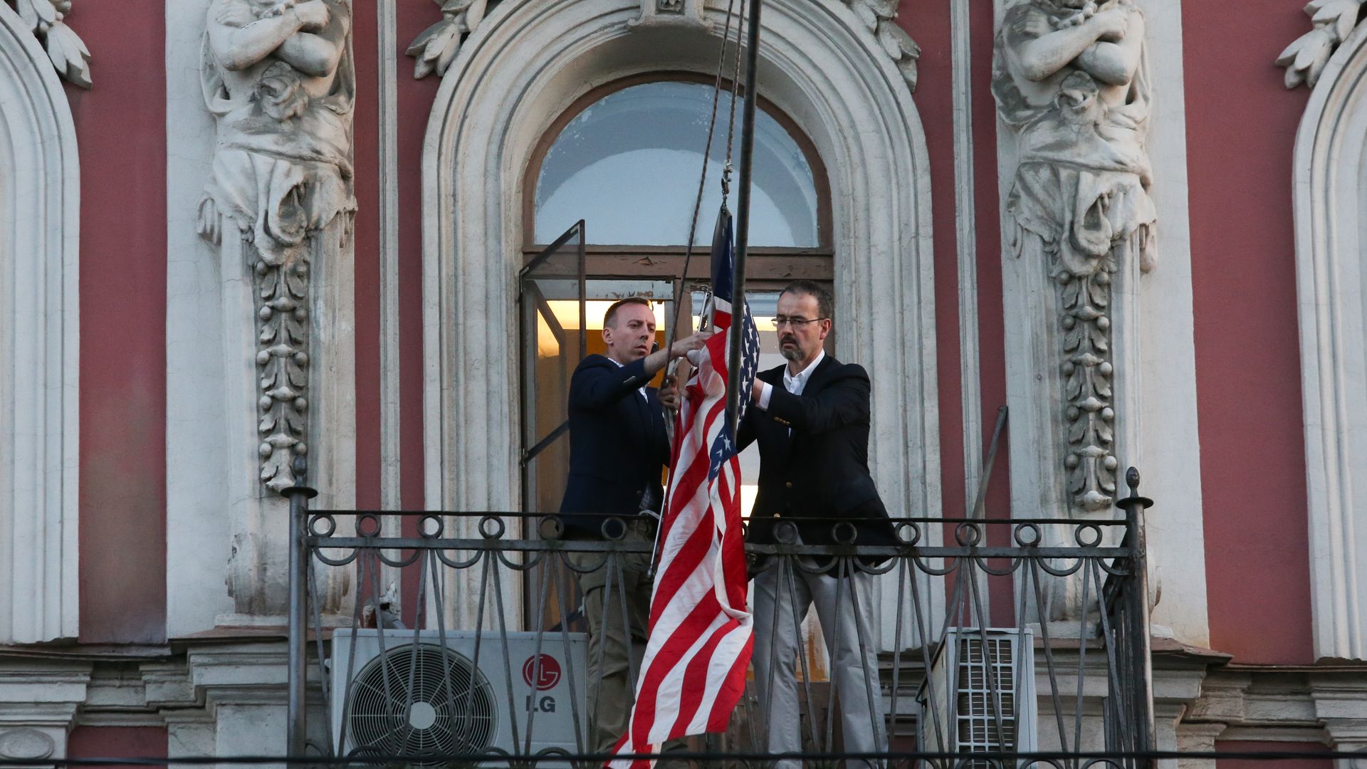 Employees remove the national flag of the United States from the building of the US Consulate General at Furstatskaya Street in St. Petersburg.