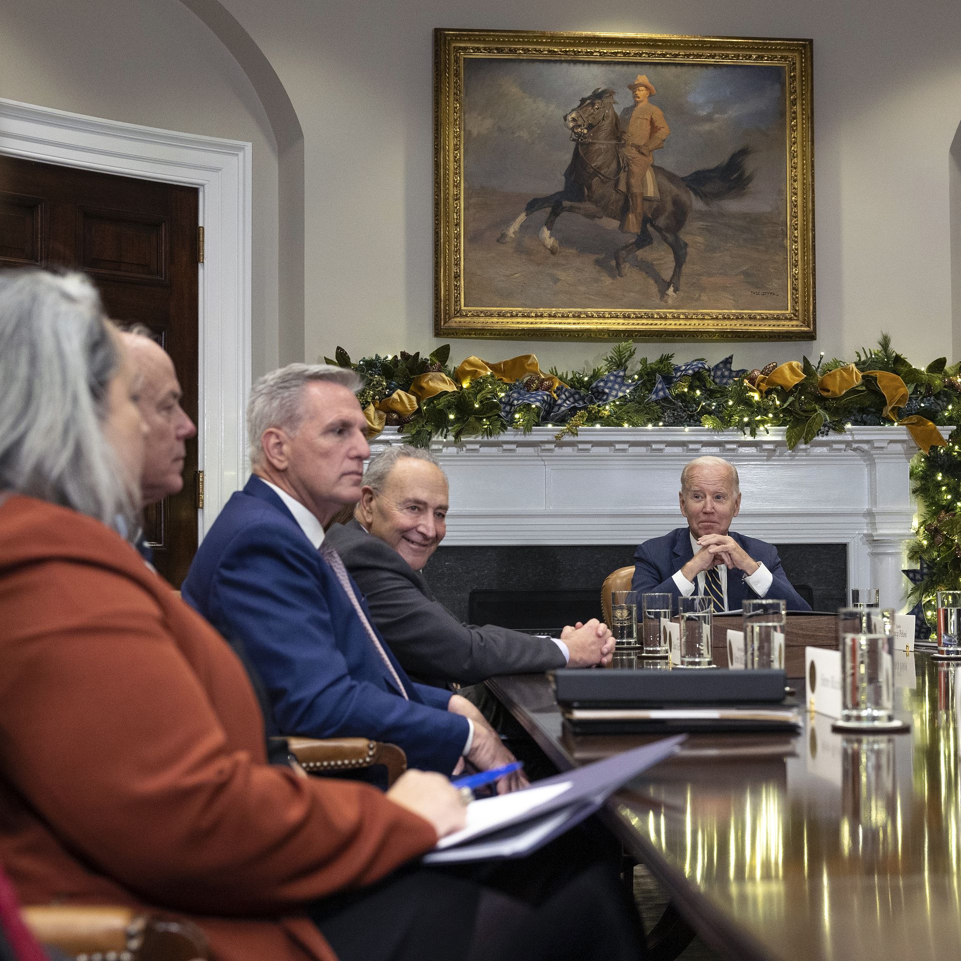 McCarthy and Biden around a table with other congressional leaders and a painting of Teddy Roosevelt presiding