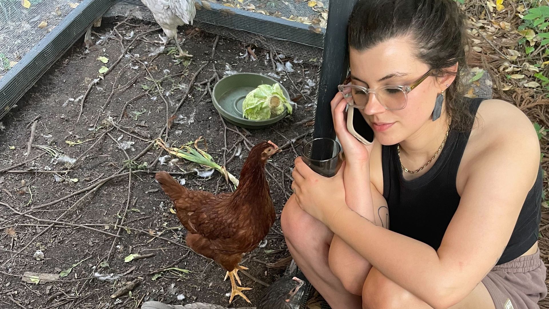 Lucille hanging out with her chickens, drinking wine and talking on the phone.
