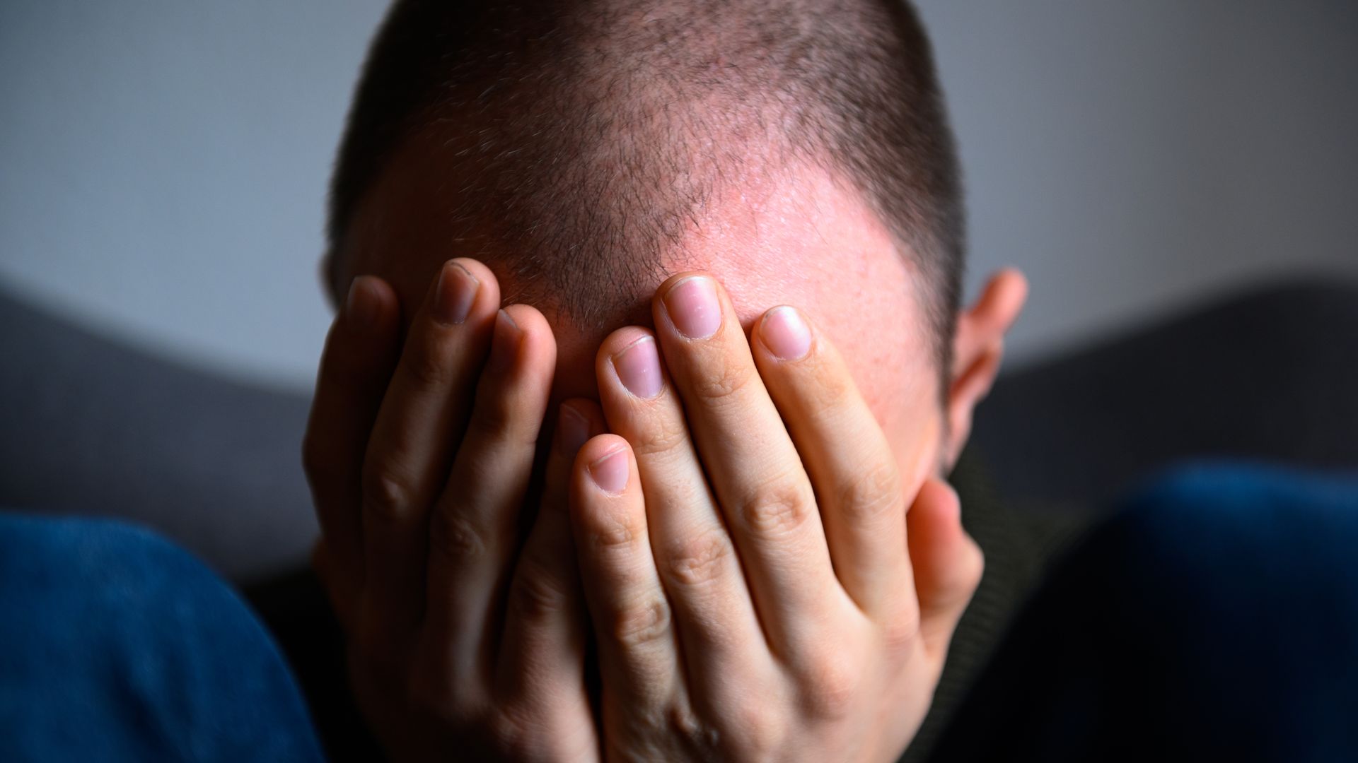 Man with head in hands. 