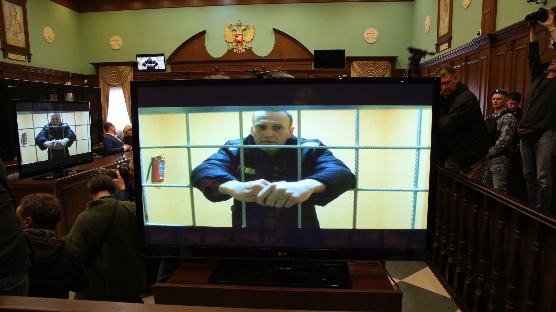 Alexey Navalny is seen on the screen during his legal appeal against his nine-year prison sentence