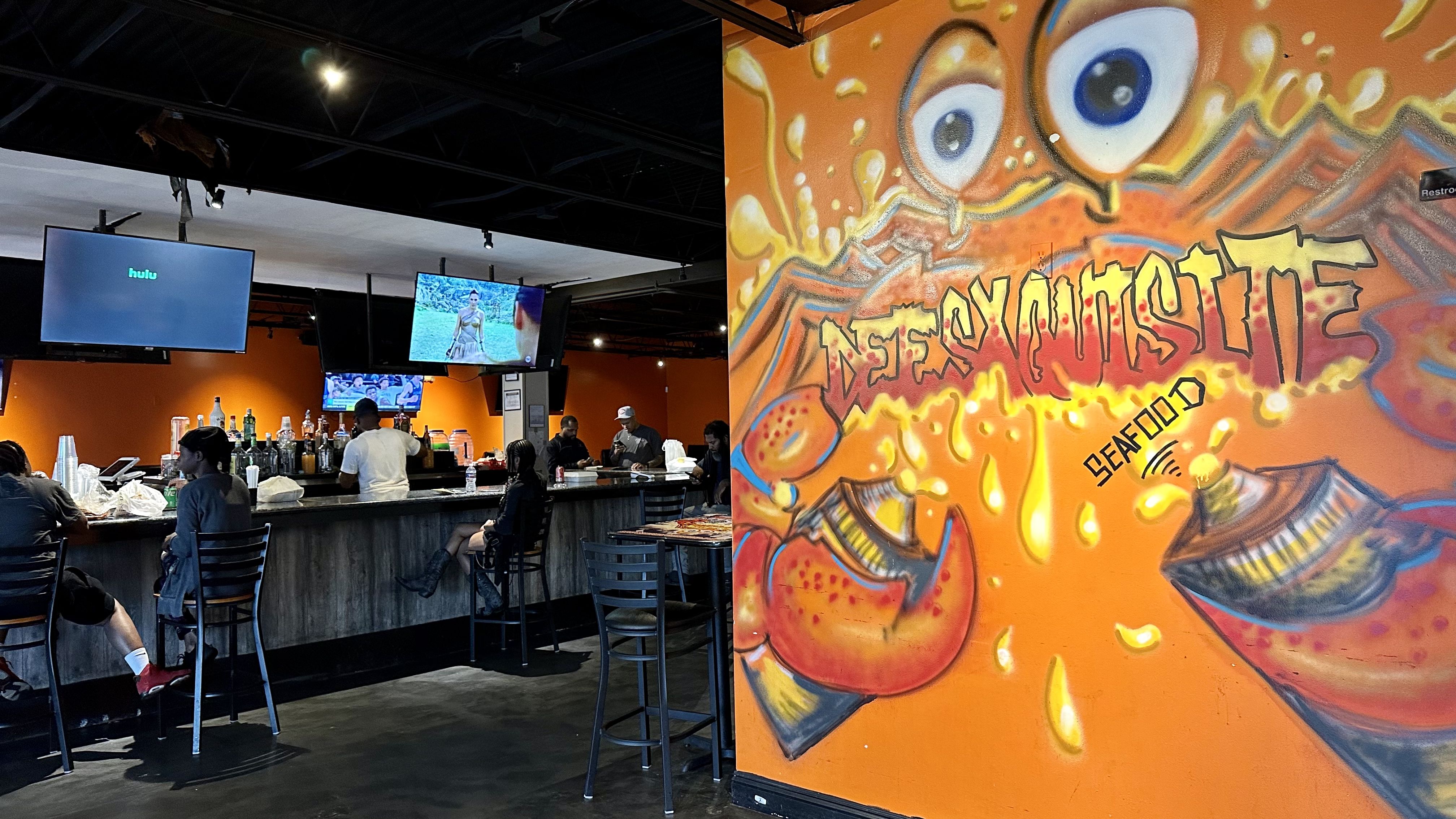 Photo shows the inside of Dee's Xquisite with a bar and a mural.