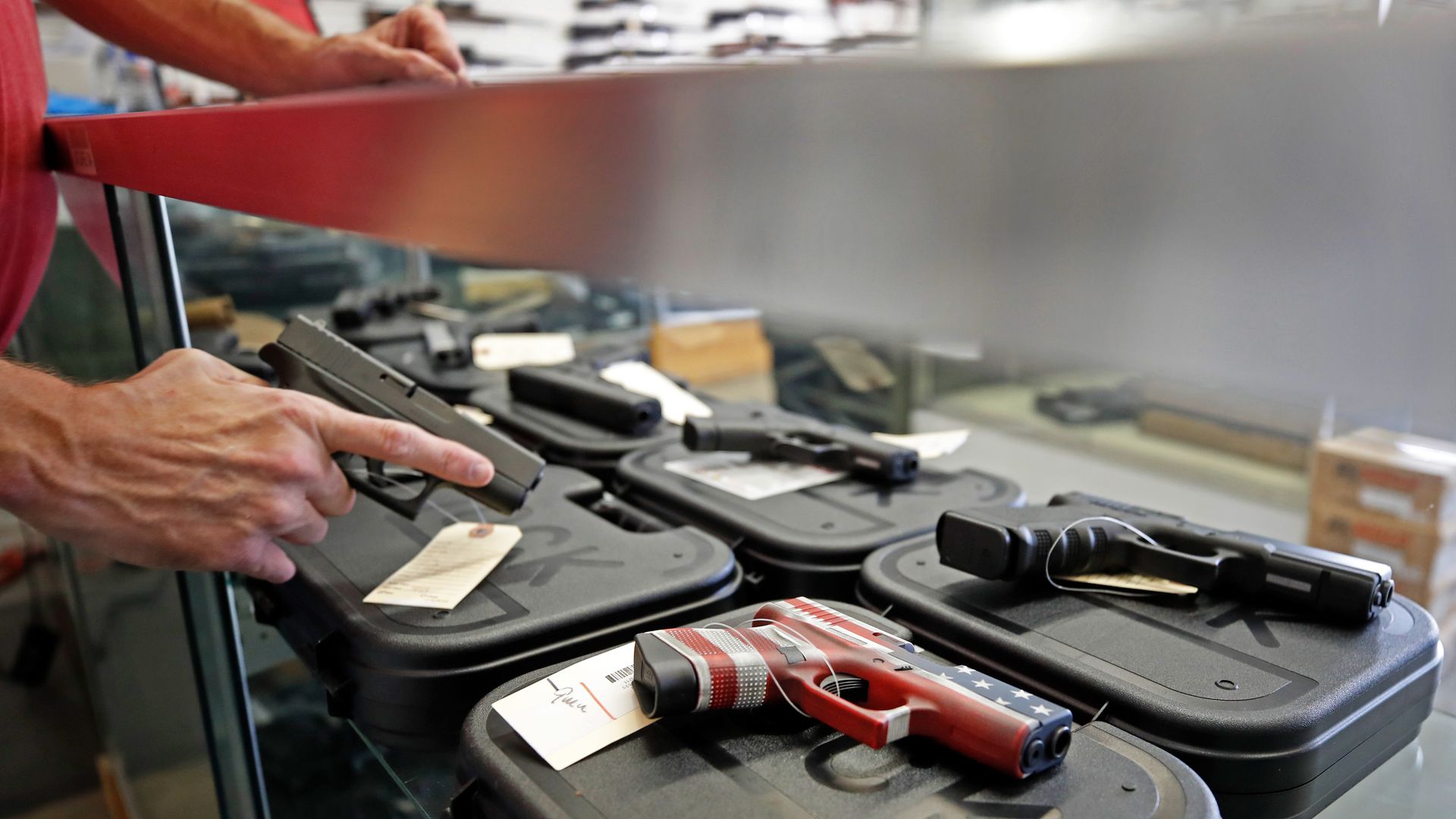 A worker restocks handguns at Davidson Defense in Orem, Utah.
