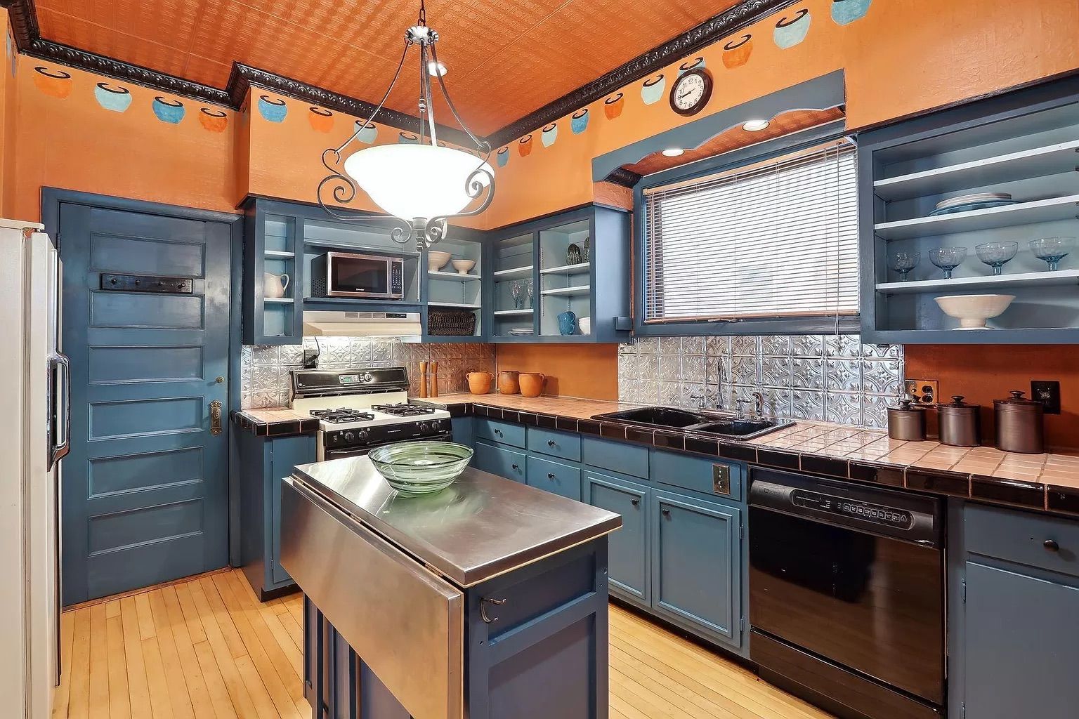A photo of an orange kitchen with blue cabinets.