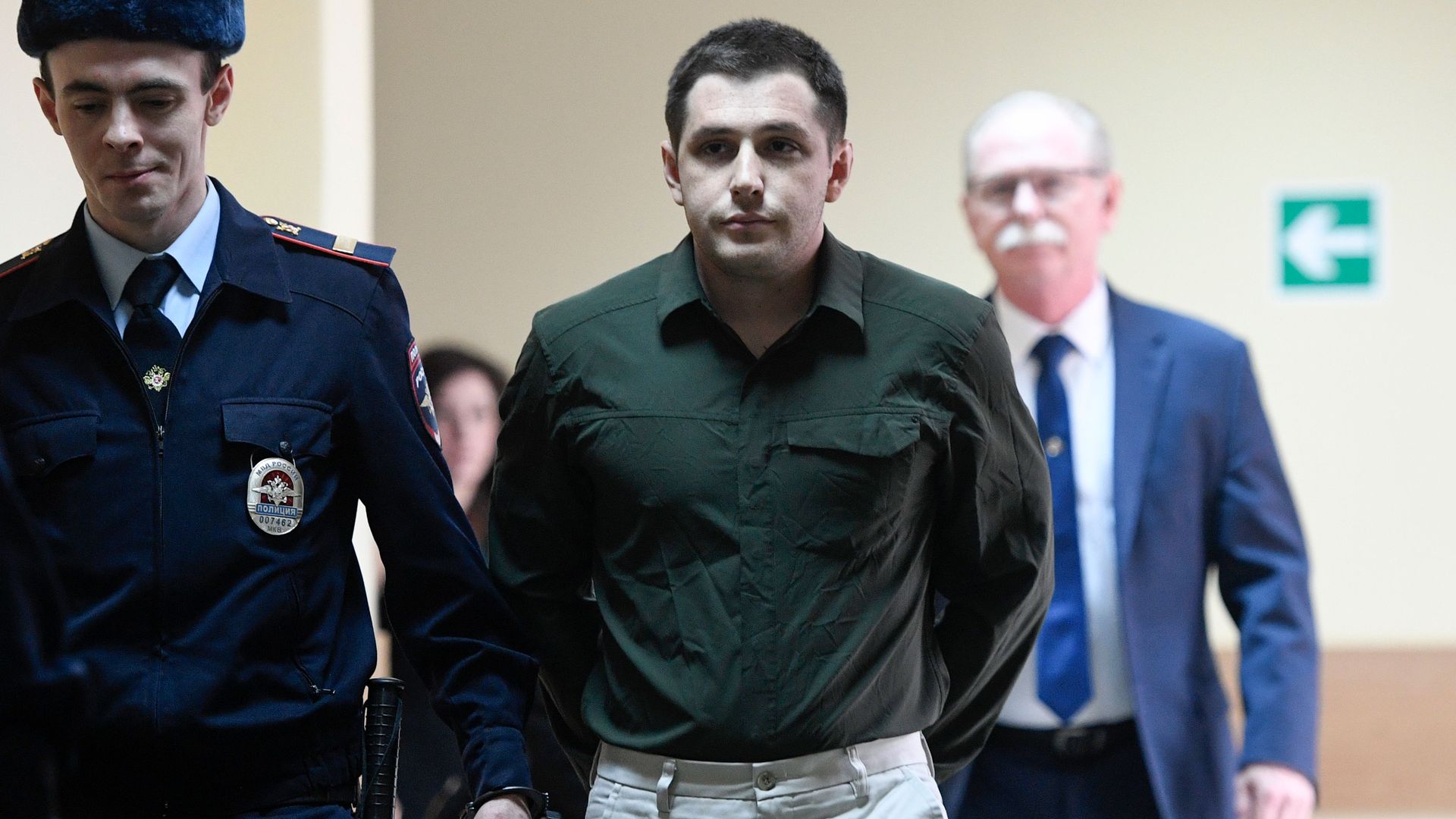 revor Reed, charged with attacking police, into a courtroom prior to a hearing in Moscow on March 11, 2020