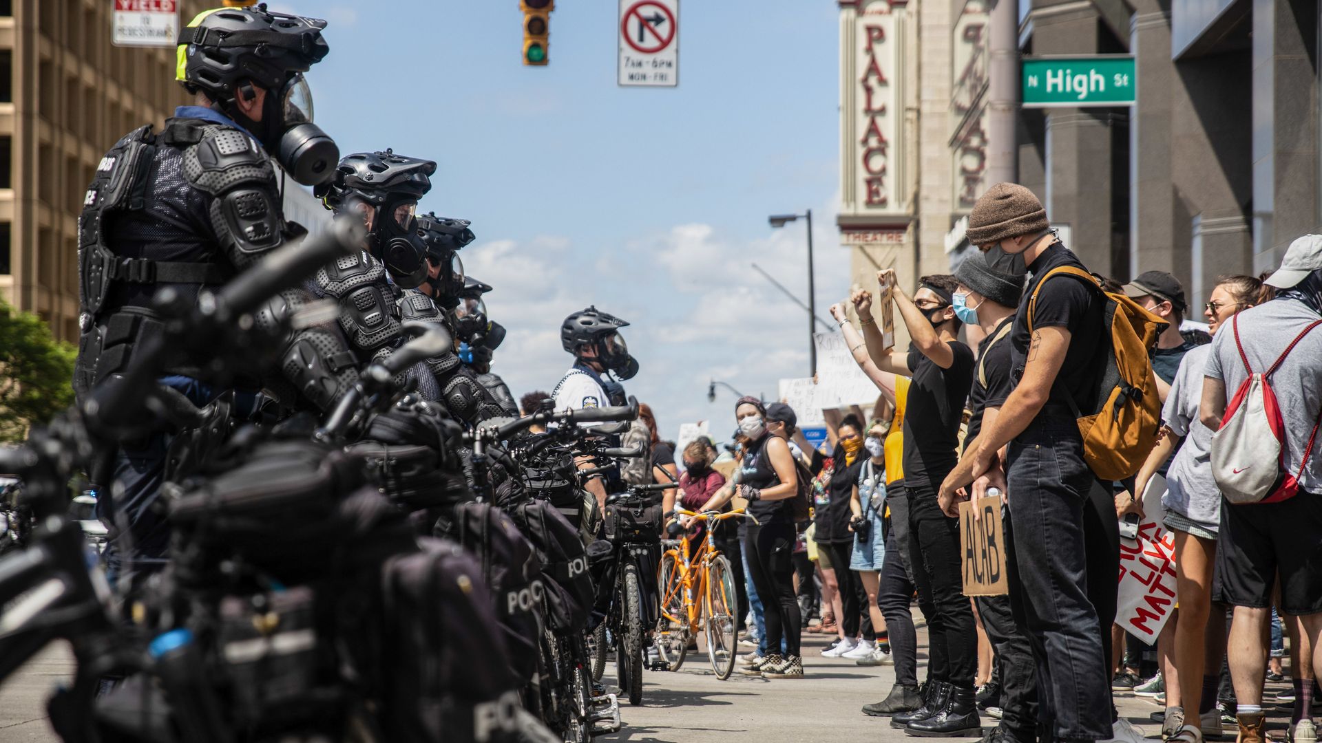 Protesters and police officers stand in lines facing each other in the intersection of High and Broad streets during the 2020 protests