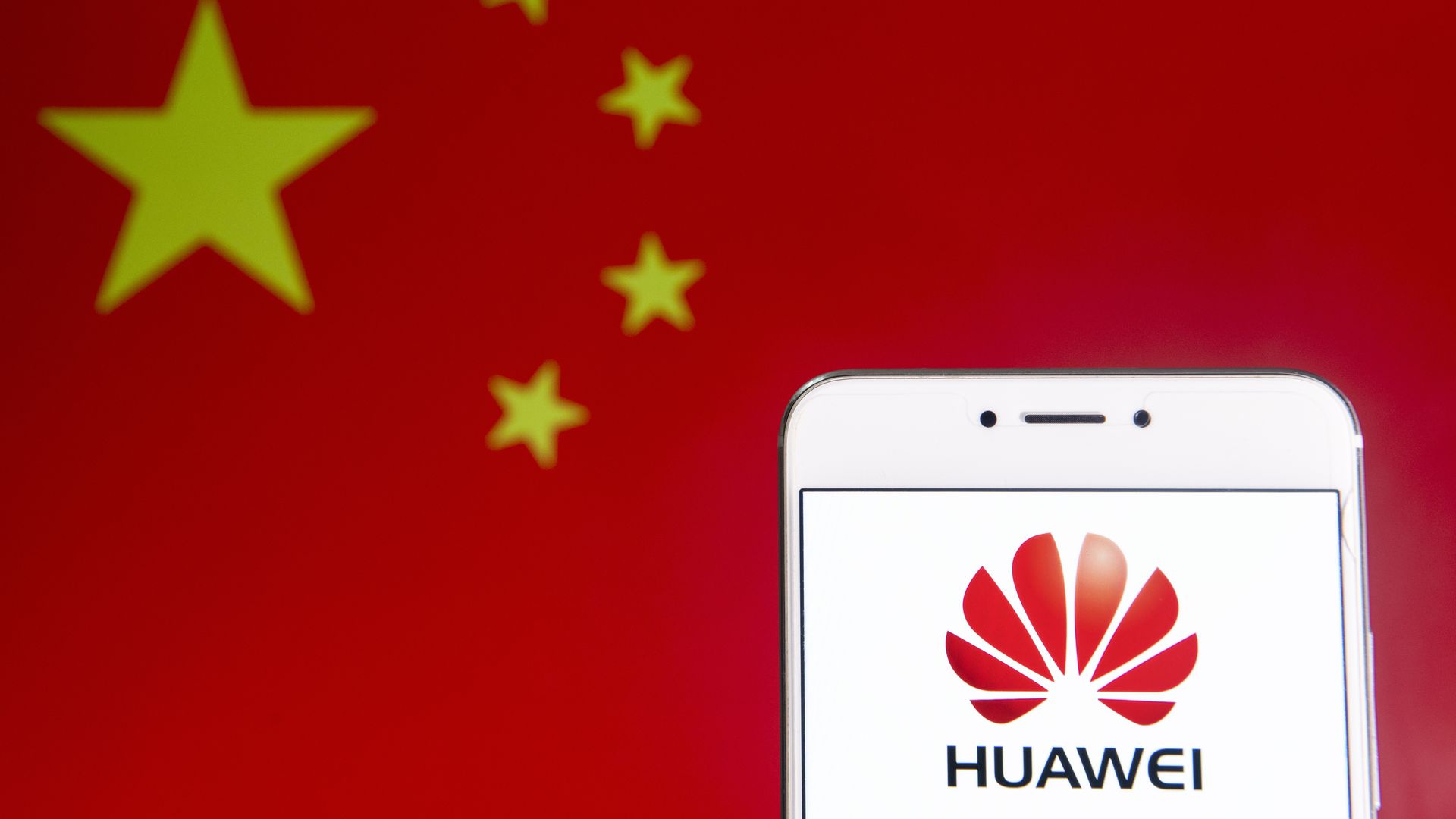 Huawei logo on a phone screen in front of the Chinese flag