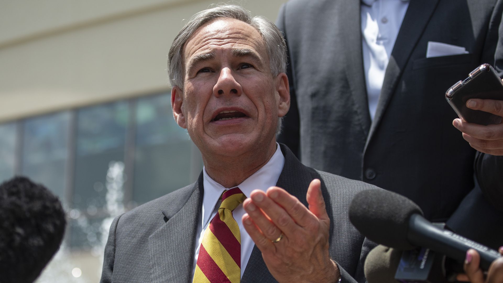 Texas Governor in a suit and tie speaks to reporters 