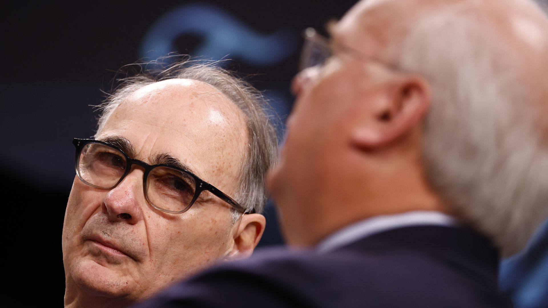 David Axelrod turns to Karl Rove, who's blurry in the foreground.