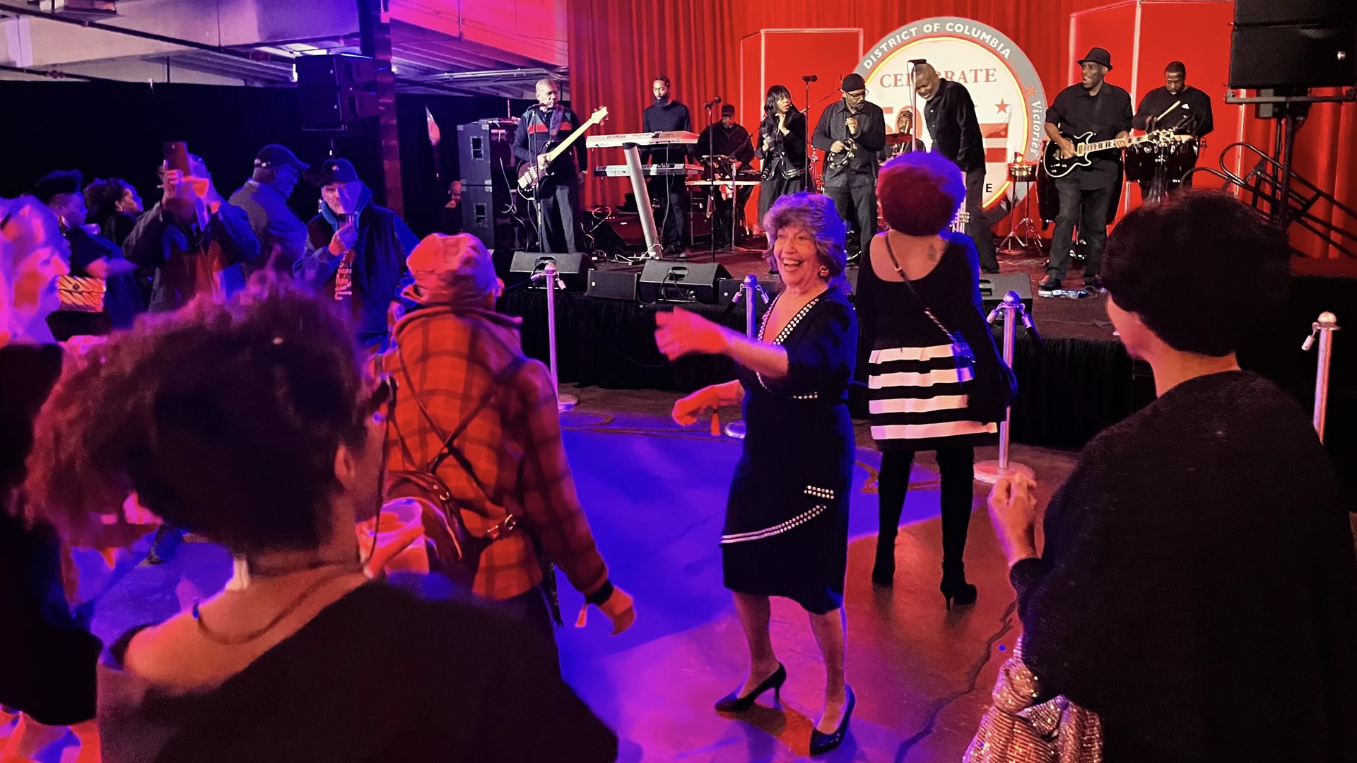 People dancing while a band performs on a stage