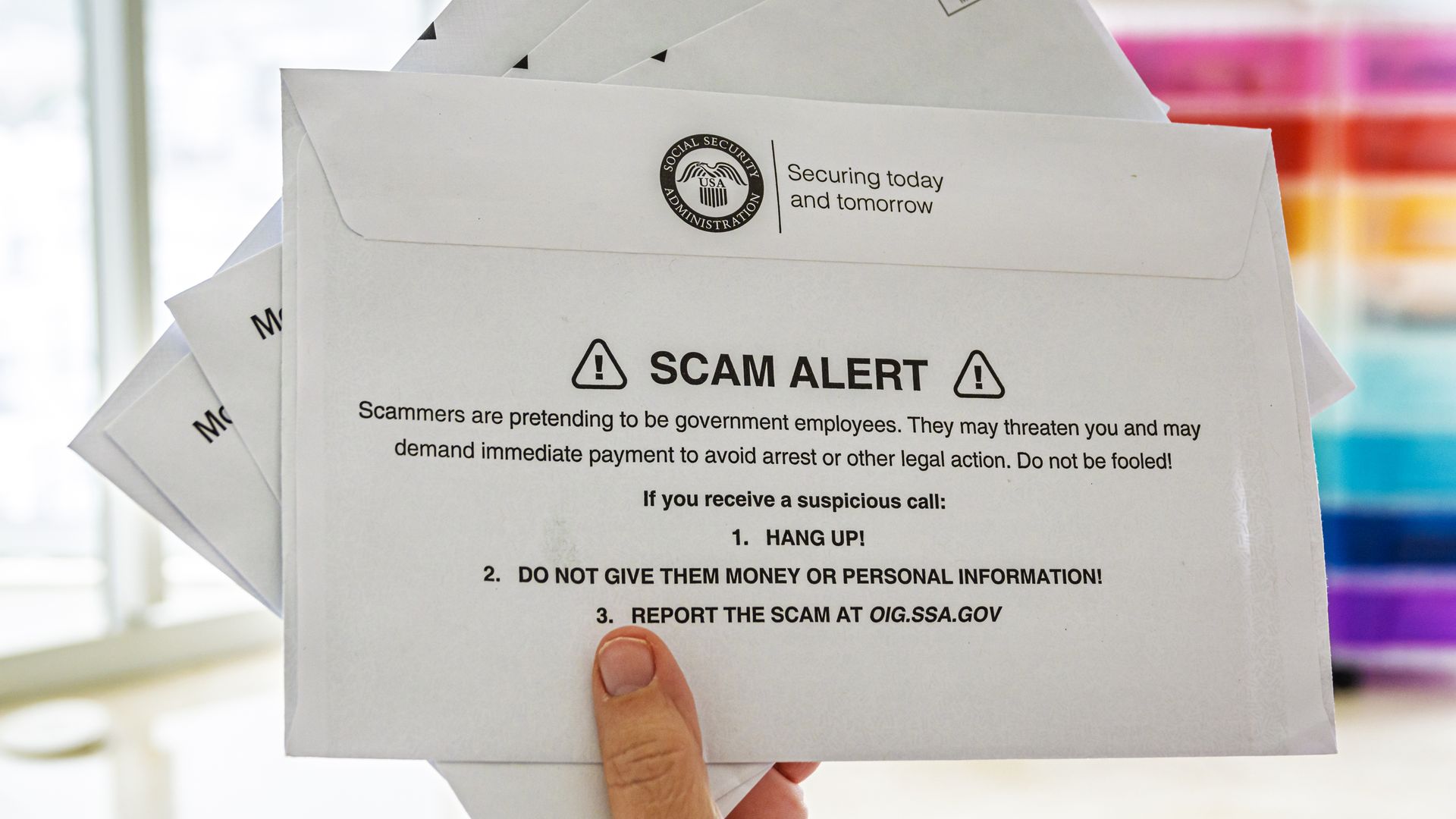 Hand holding, Social Security Administration, letter envelope, message warning, scam alert.