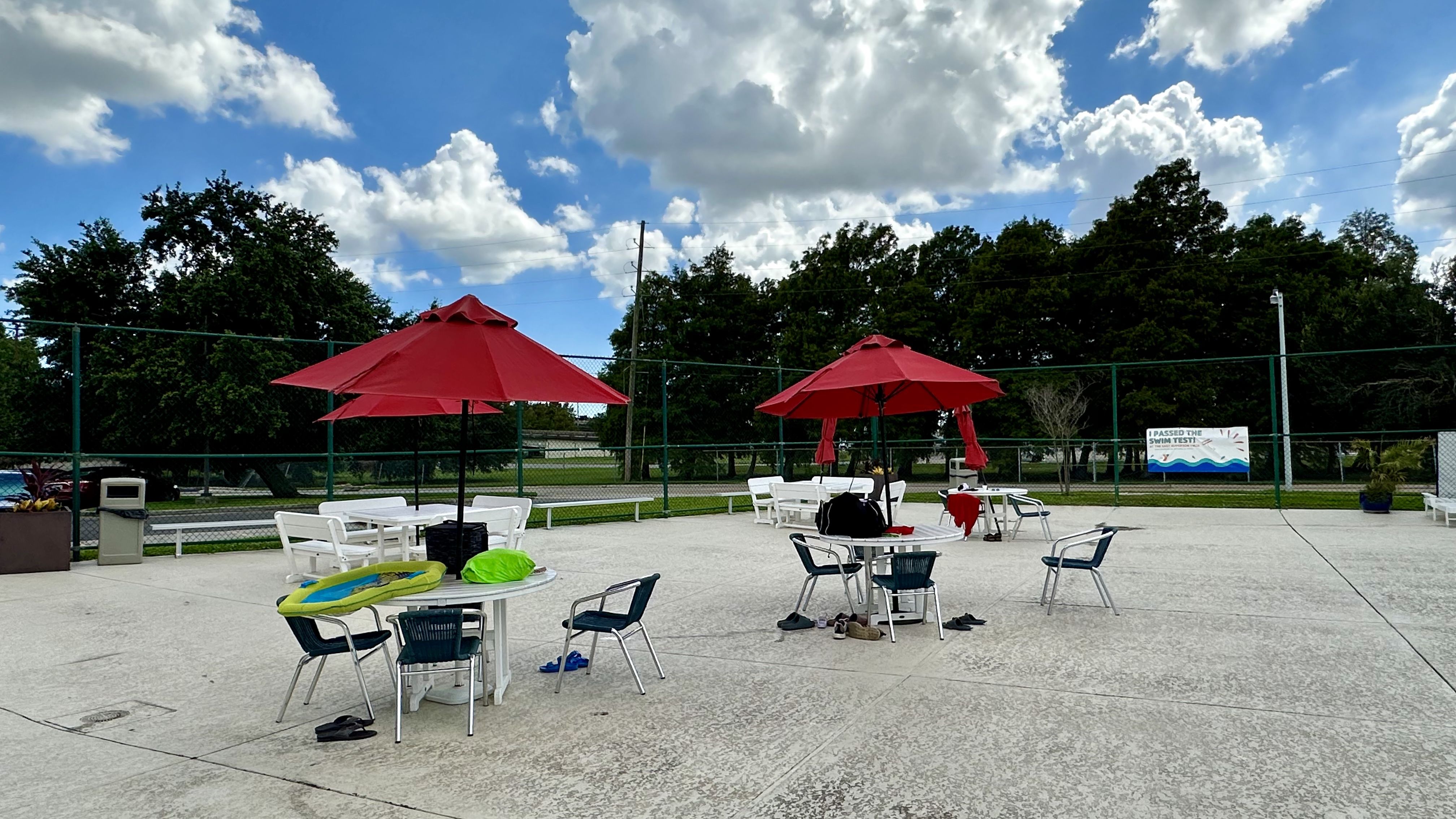 Photo shows tables with red umbrellas
